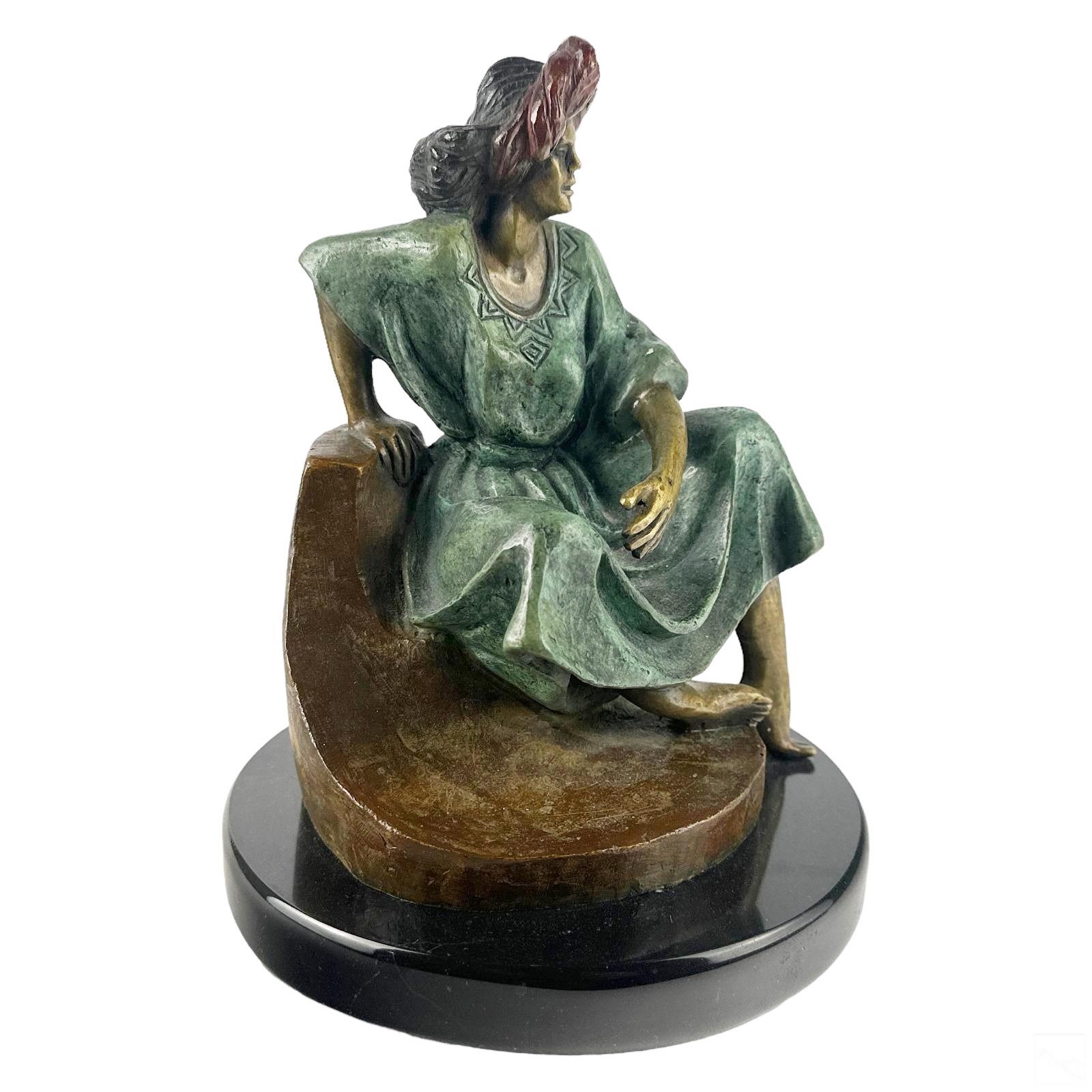 Victor Gutierrez (Mexican, Born 1950). A limited edition cold painted bronze statue. A figural work produced in a modern style depicting a seated female figure in traditional Mestizo style costume, with a red head wrap, modeled on a Modernist base.