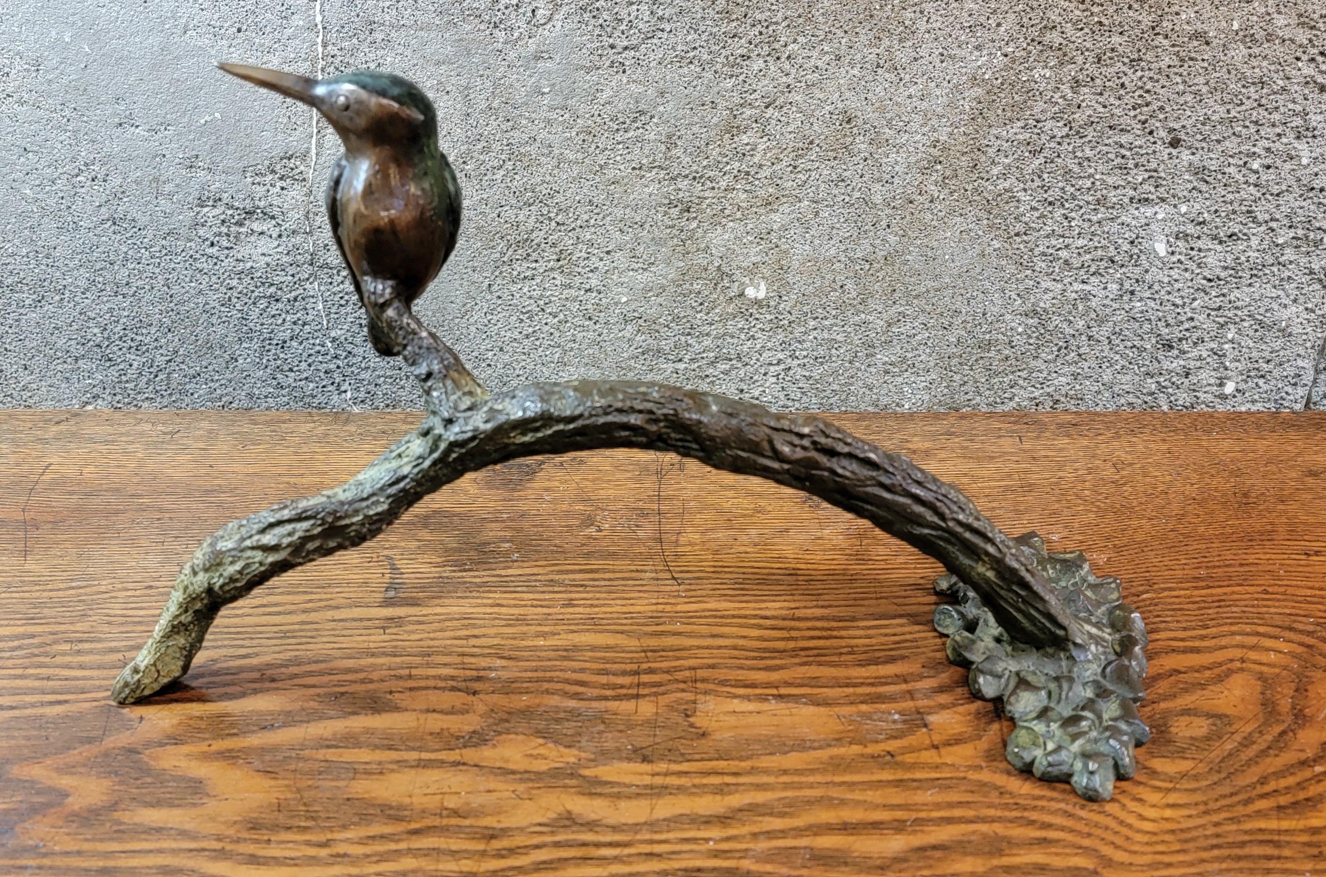 A cast bronze sculpture of a bird perched on a branch. Signed Denis Mathews and dated 1996. Appears to be numbered limited casting but numbers are indecipherable. Measures 14 inches wide. Denis Mathews (British b. 1913).