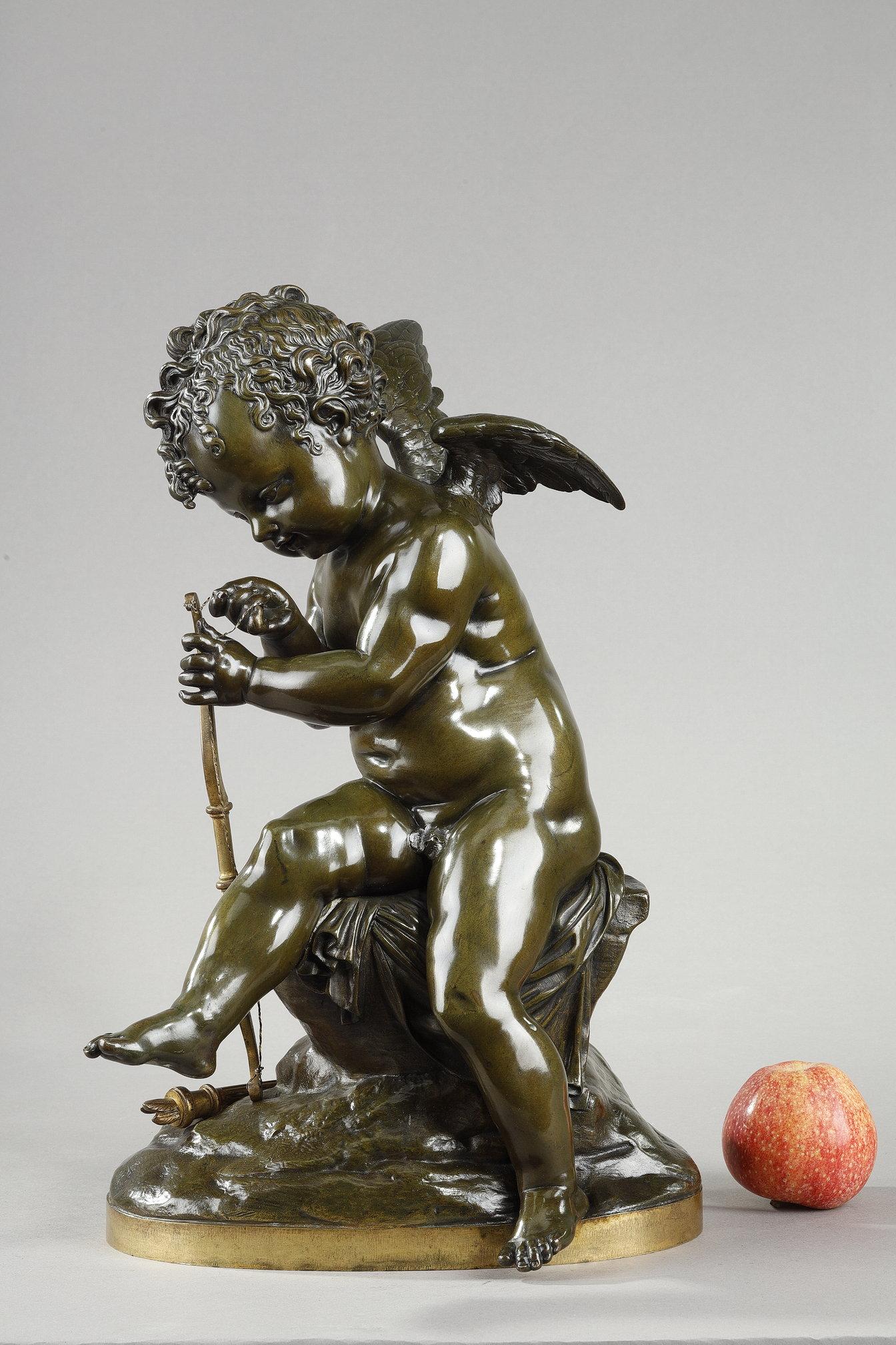 Green patina bronze proof of a cupid stringing his bow, after a marble original presented at the 1814 Salon by Charles Gabriel Sauvage dit Lemire (1741-1827). Love is shown seated and concentrating, fastening his bowstring with the quiver at his