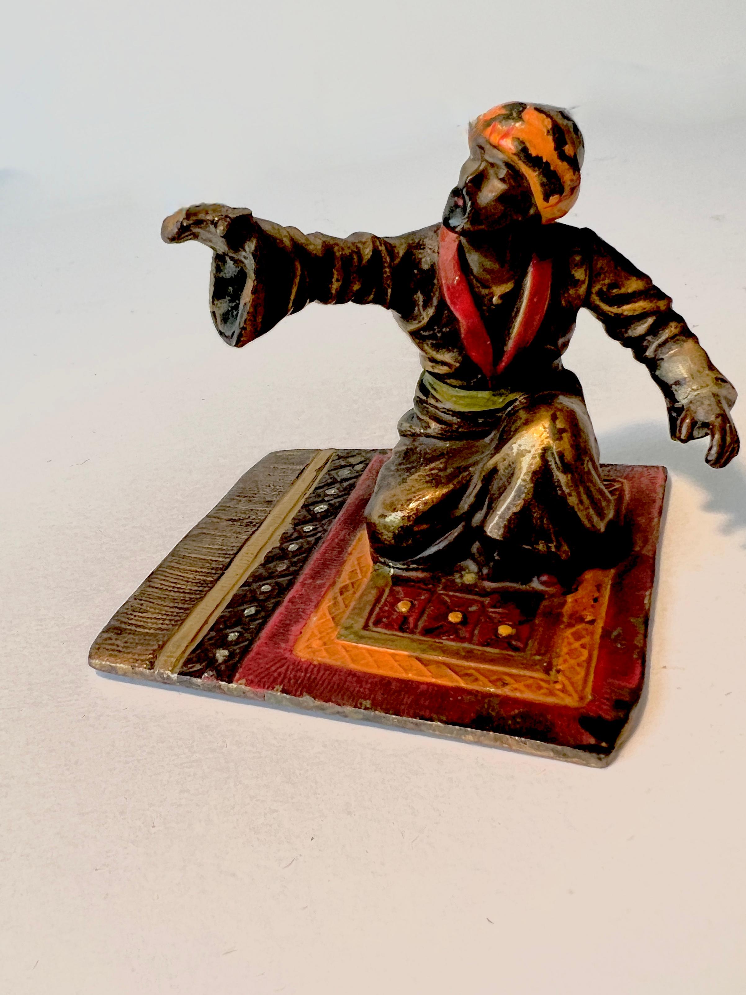 Escultura de bronce de un hombre de Oriente Medio sobre una alfombra al estilo de Franz Bergmann Hecho a mano en venta