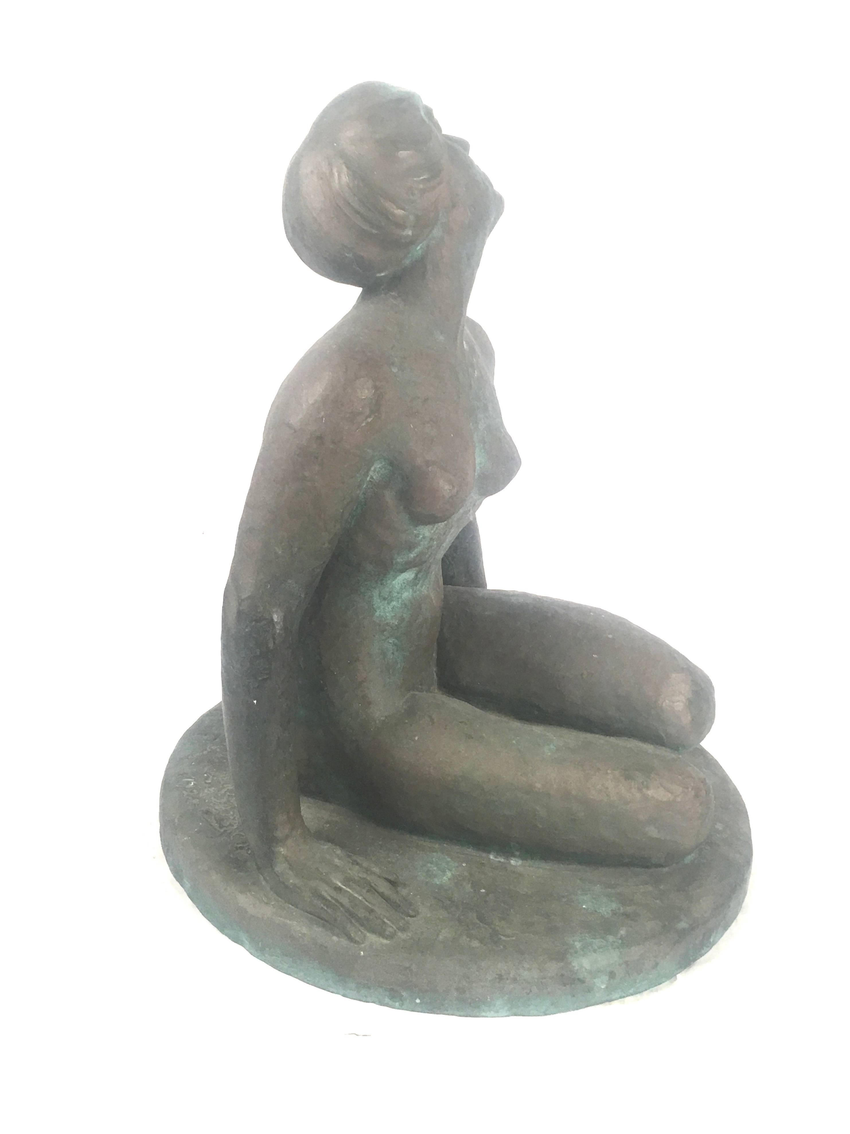 An expressive bronze sculpture of a seated nude woman by Leo bergere (Swiss, 1885-1983), her head tilted and looking upward, her legs crossed, leaning on her right arm with her left wrist resting on her ankle, on a circular base. Signed and dated on