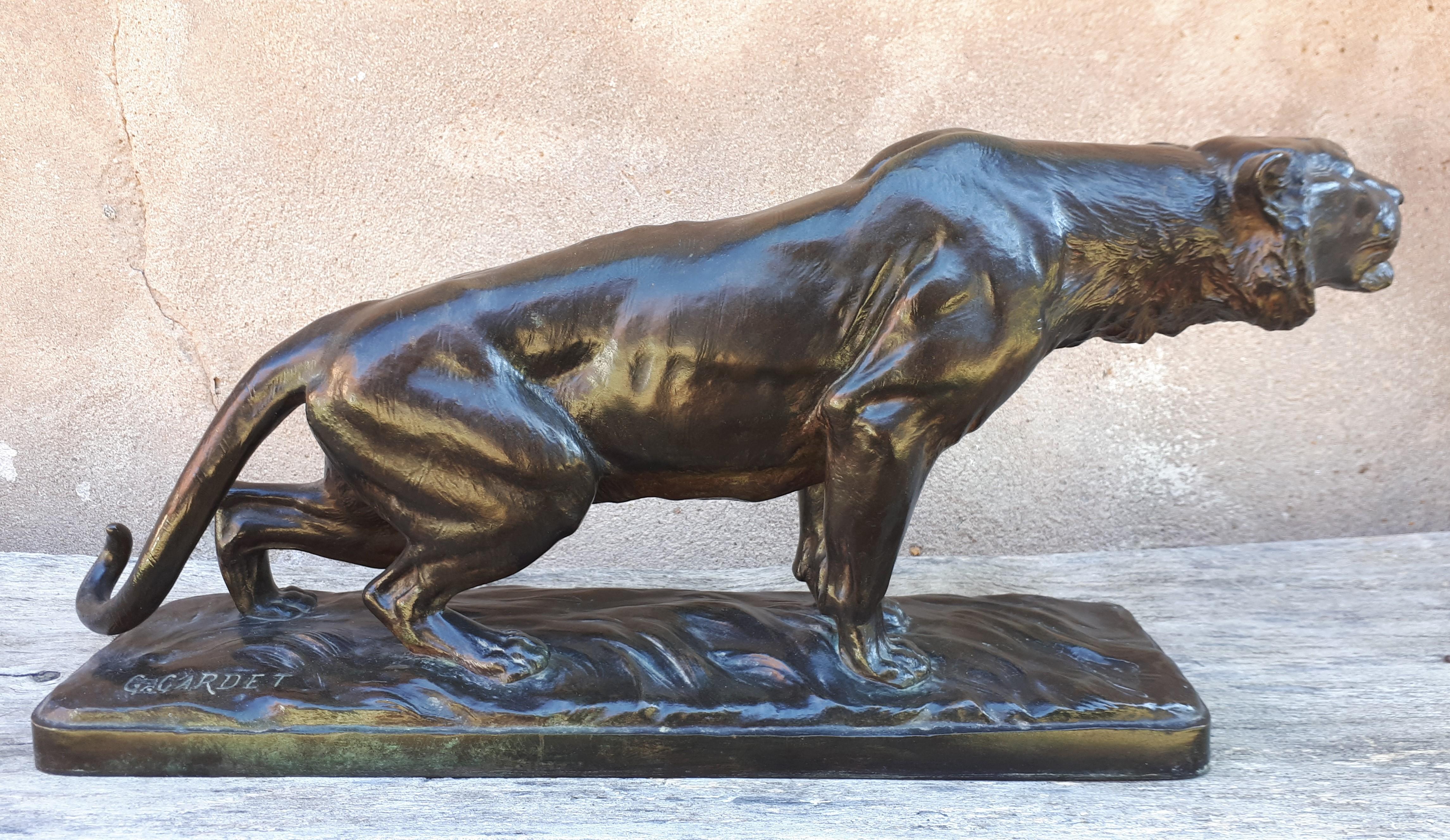 Sculpture en bronze à patine brune avec des nuances vertes représentant un tigre à l'affût.
Signé 