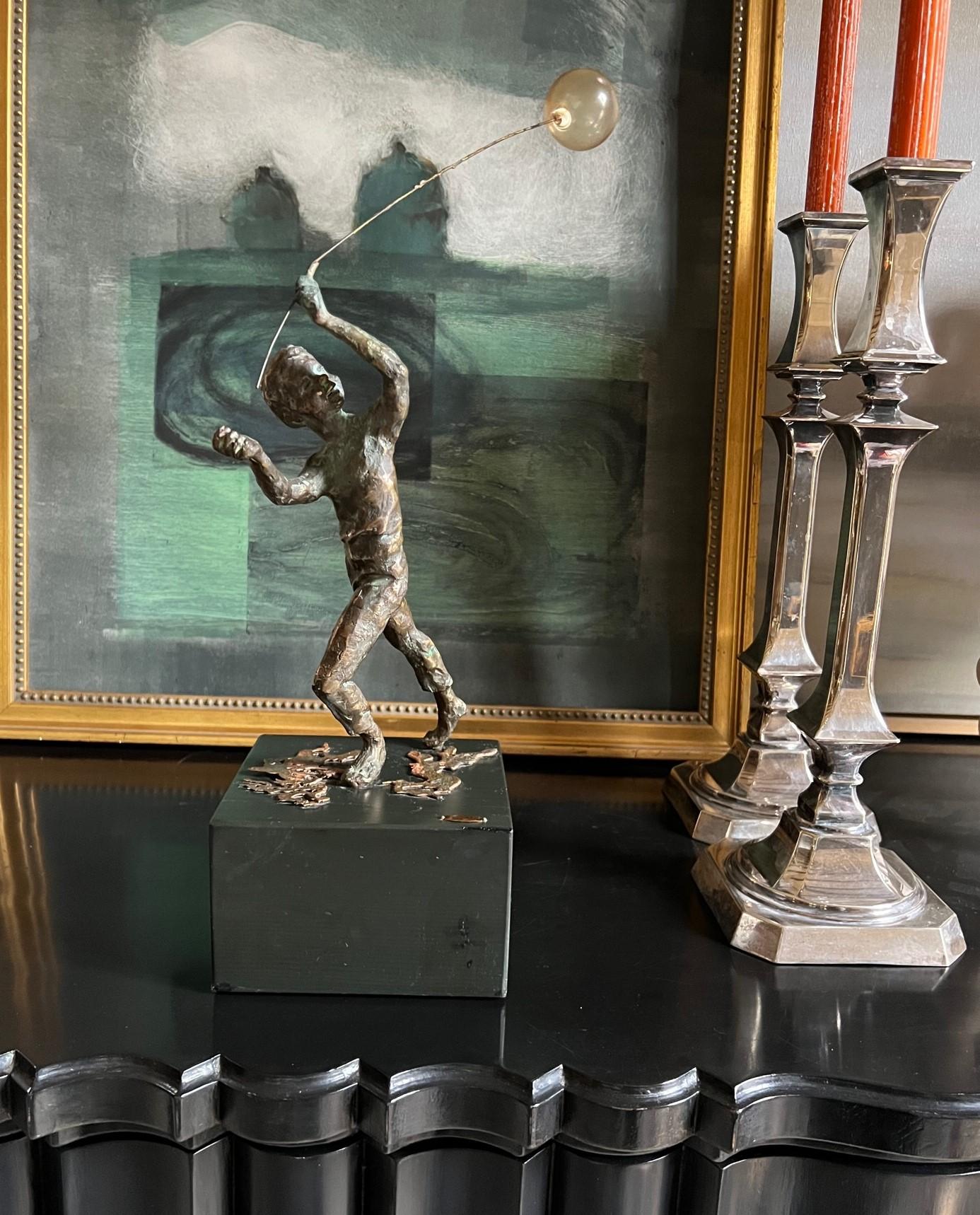 Bronze sculpture of boy playing with a blown glass balloon by Curtis Jere.

The bronze boy measures 13.5 inches tall, from the base to the top of the balloon is 16.5 inches tall.