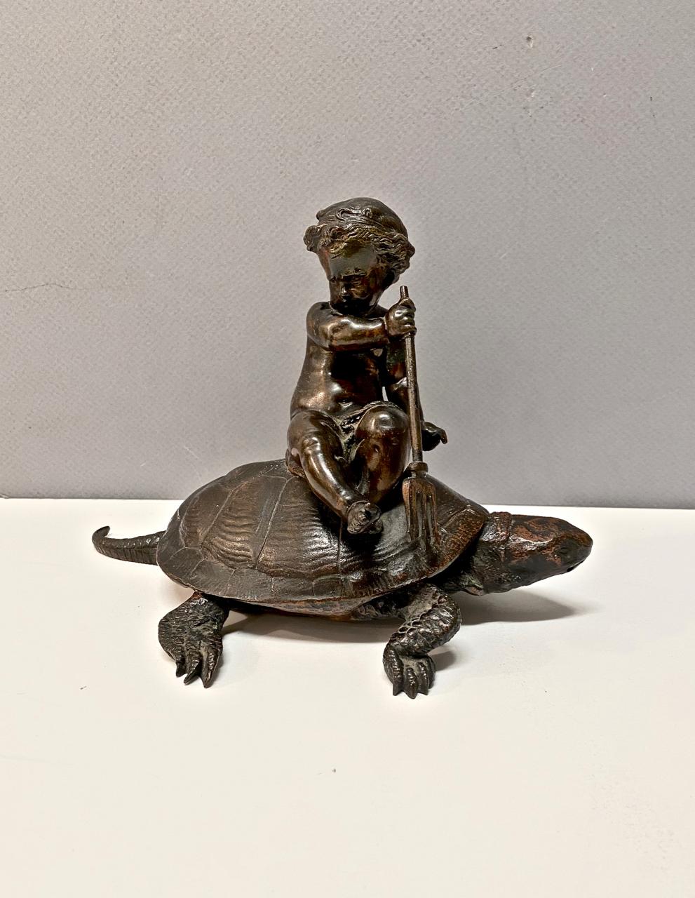 This is a charming figural sculpture of a Putti with trident riding on a tortoise. To the ancient Greeks and Romans, the tortoise was a symbol of love and fertility; the tortoise was considered an attribute of Aphrodite. For the Japanese, the