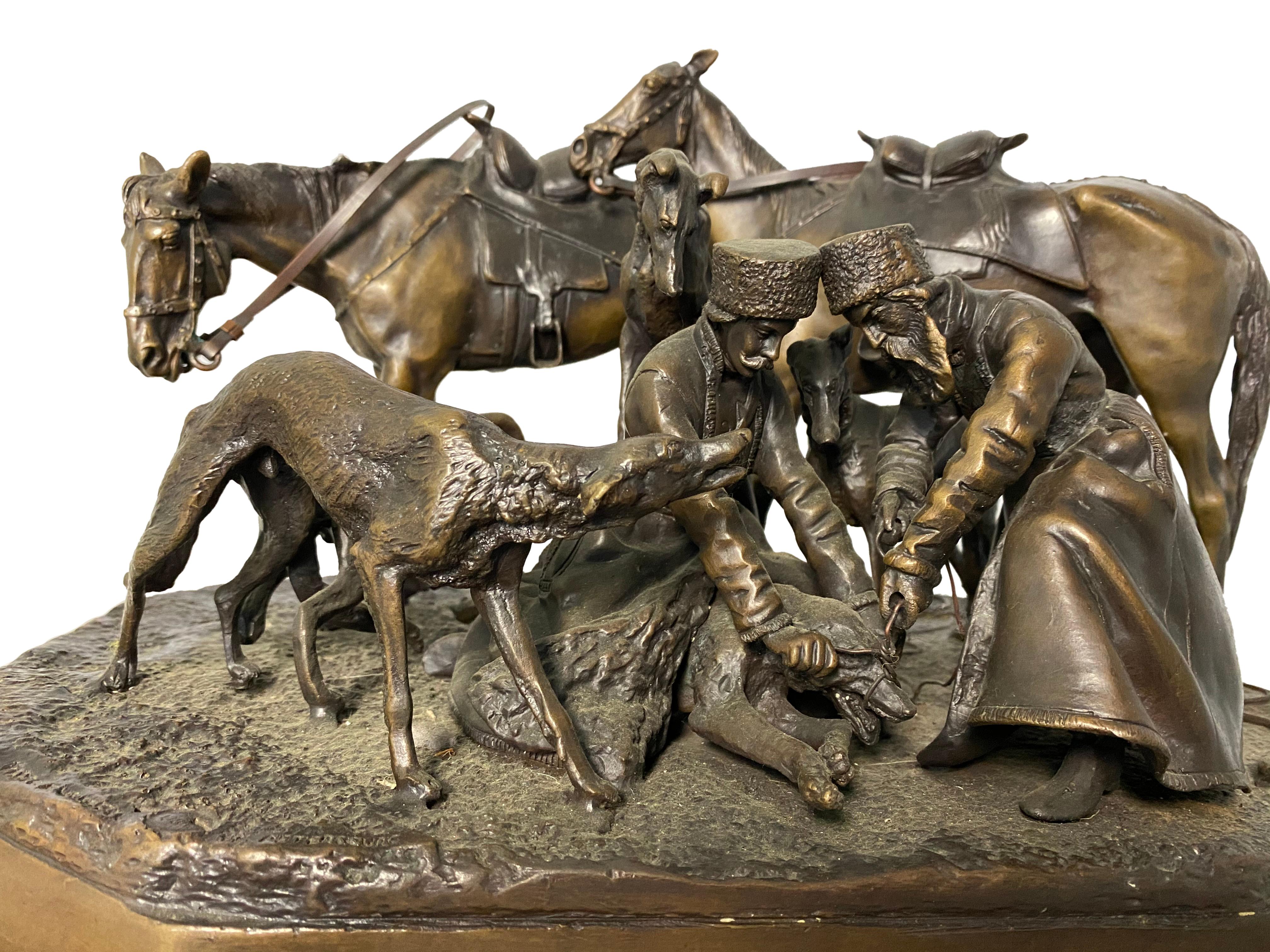 This detailed bronze sculpture of a hunting party depicts two men who are knelt next to their horses surrounded by hounds. The two men are restraining one bear tending to its face. 

Dimensions: (cm)
H32/ W 53/D 37.
 