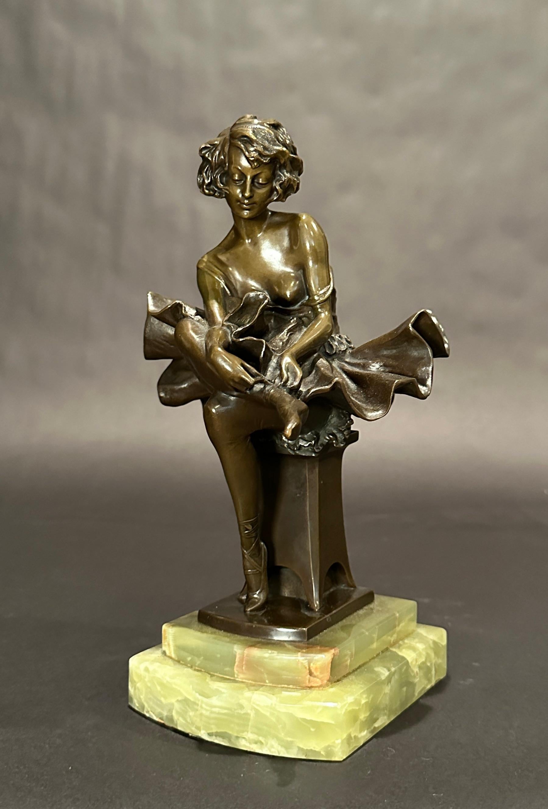 Period Art Deco bronze sculpture by Josef Lorenzo (1852-1950) of a beautiful ballerina seated with a pleasant gaze, in traditional outfit of tutu and tying her pointe shoes in preparation for practice or performance. Rich brown patina mounted on an