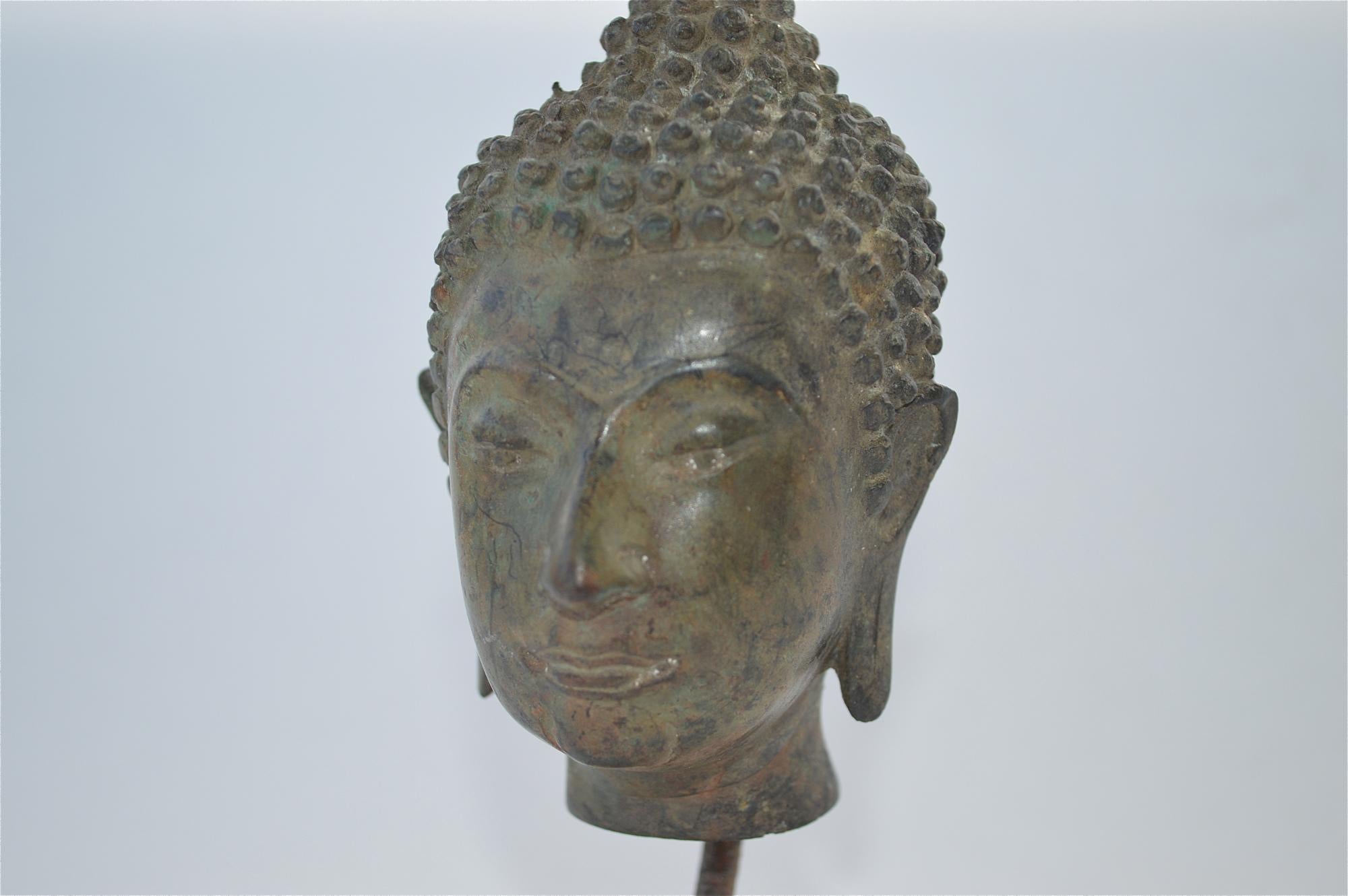 Good quality sculpture of the head of Buddha, cast in bronze with a patinated finish and standing on a marble base. Probably a museum replica after the antiquity and dating from circa 1950s-1960s. Measures: 17.3cms tall, 6 3/4 inches tall.
