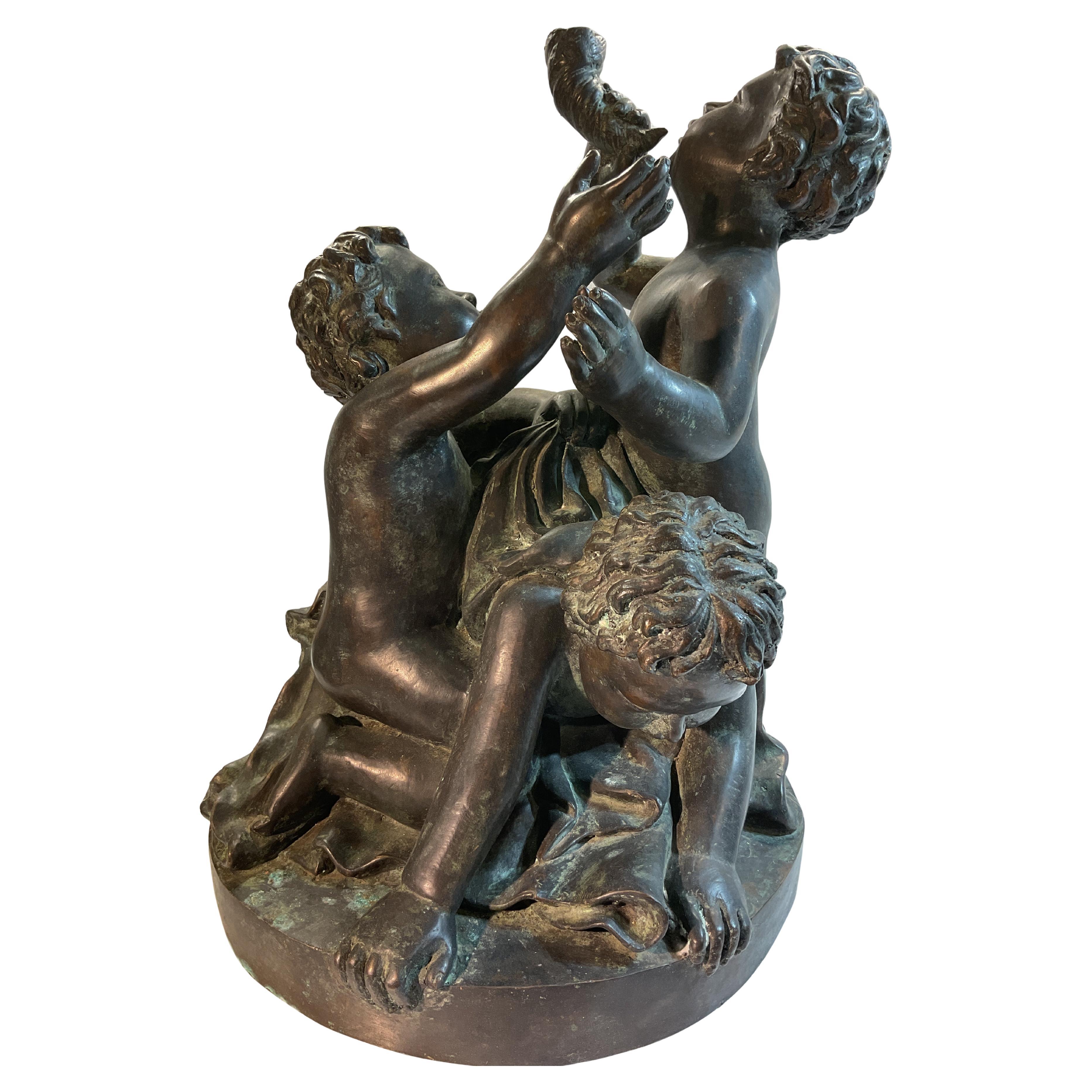 Escultura de bronce de tres niños jugando