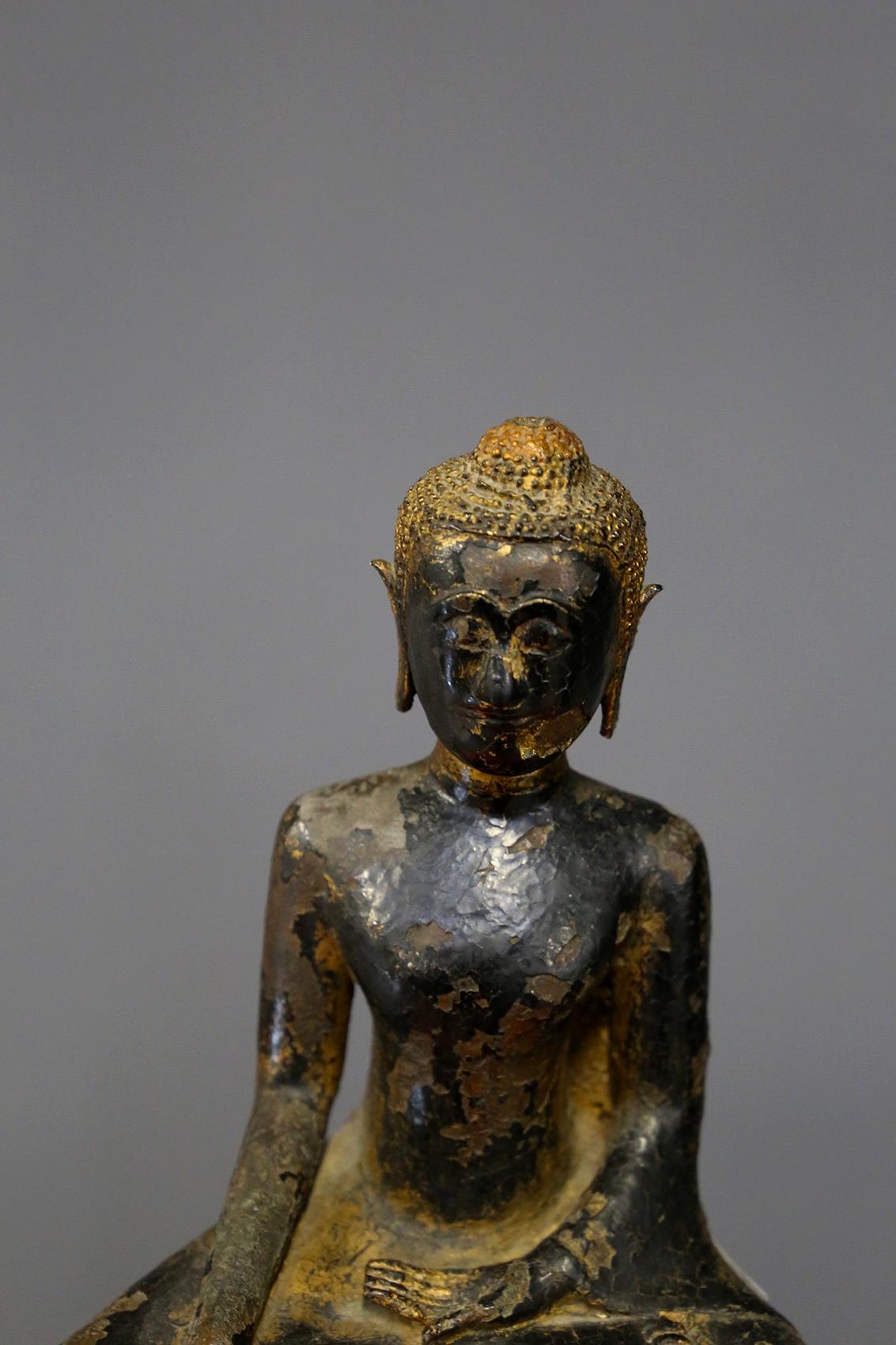 Bronze sculpture partially gilded and painted refining a 'BUDDHA'. Thailand, End of the 18th century. In the Bhumisparsha mudra (posture), sitting on a multi-layered base with traces of the original red lacquer. The sculpture is in good condition