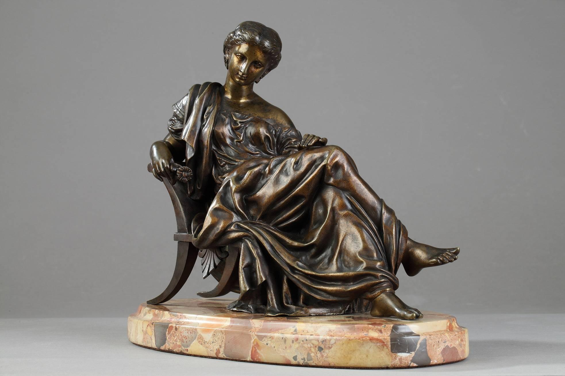 Statue en bronze à patine dorée représentant une dame classique assise d'après James Pradier (1790-1852). Elle est posée sur un socle ovale en marbre Brèche d'Alep. Ce bronze est inspiré de Sappho:: une statue en marbre réalisée par Pradier en