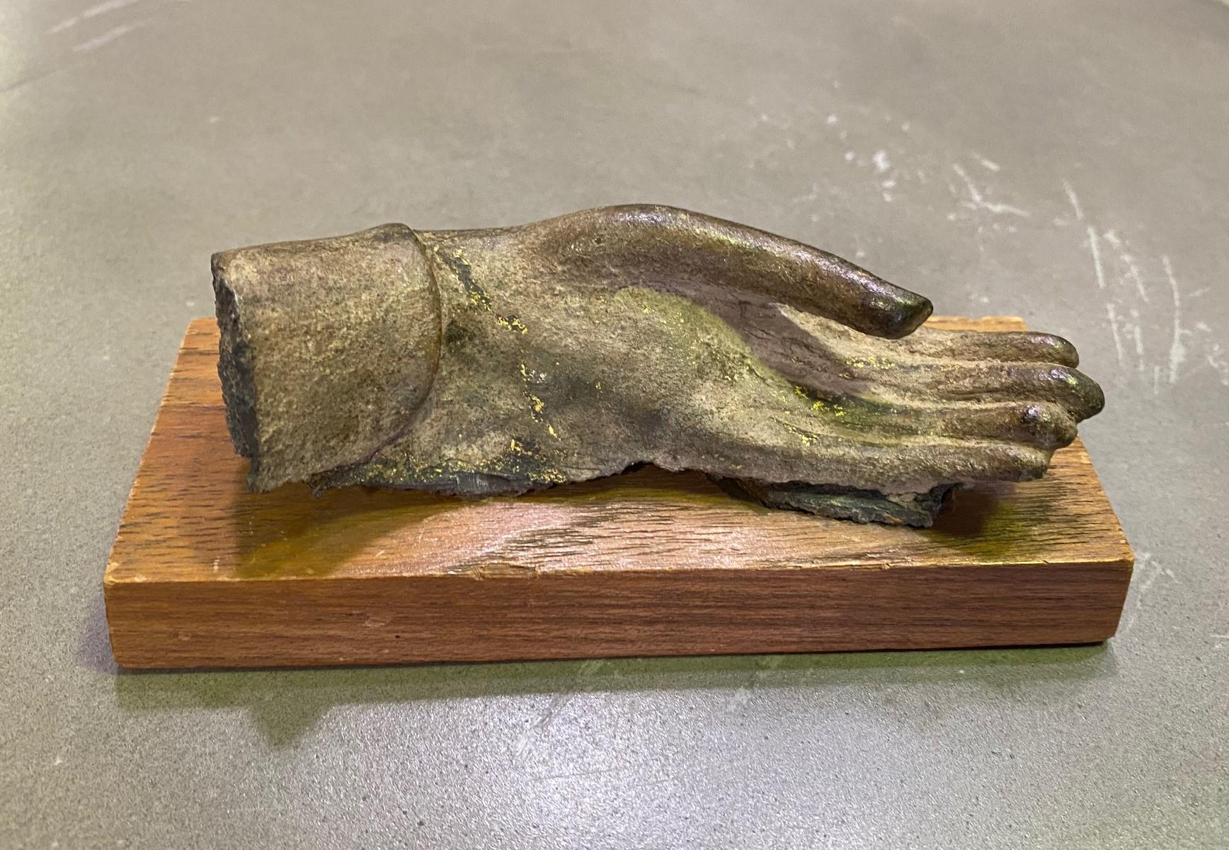 A wonderful and very special piece.

This bronze buddha hand sculpture, perhaps a fragment of a larger piece at one time, originally came from the prestigious Doris Wiener Gallery in New York City (please see the gallery tag on the underside of