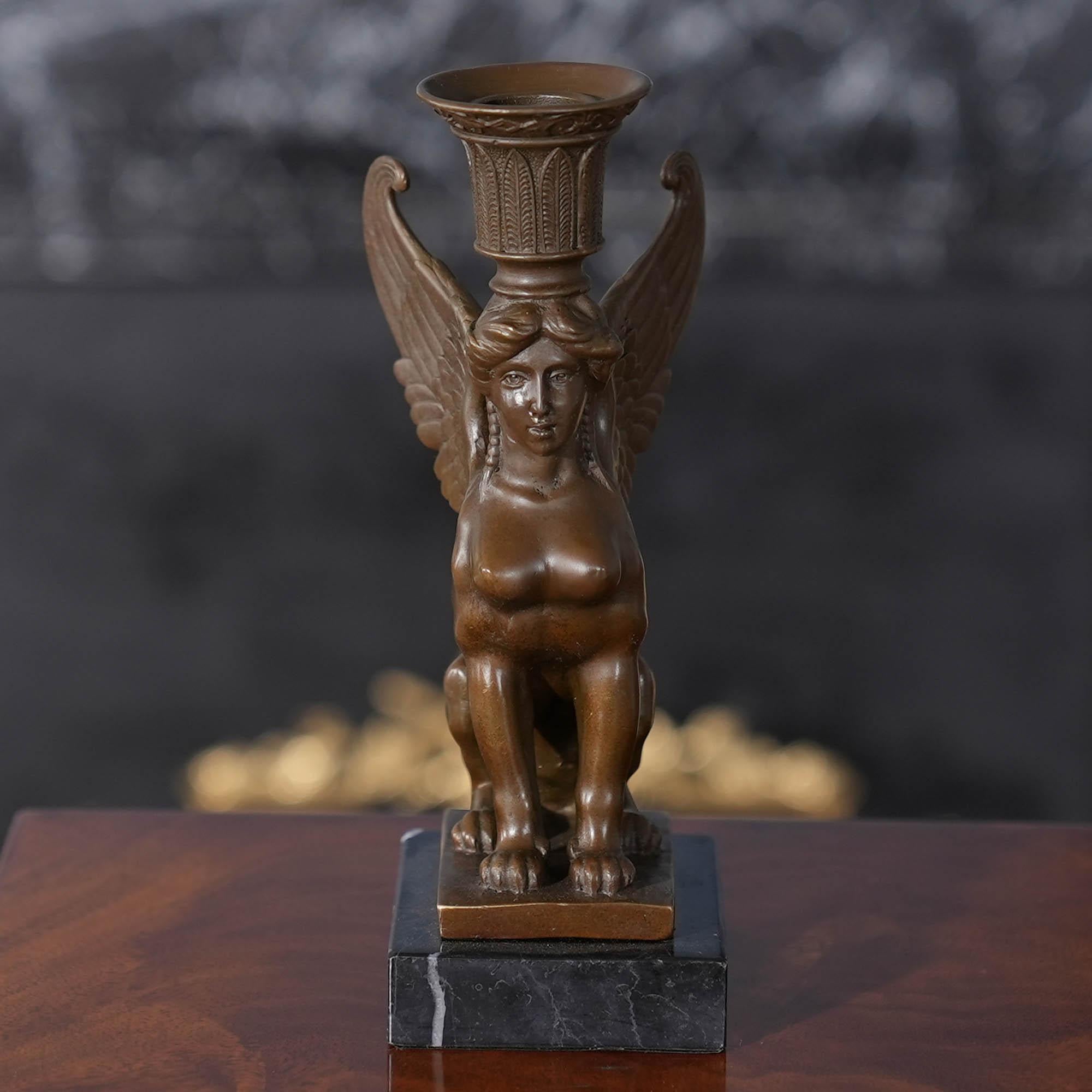 Der Sphinx-Kerzenhalter aus Bronze auf Marmorsockel ist selbst im Stillstand anmutig und stellt eine auffällige Ergänzung für jede Umgebung dar. Die Sphinx-Statue aus Bronze wurde im traditionellen Wachsausschmelzverfahren gegossen und mit