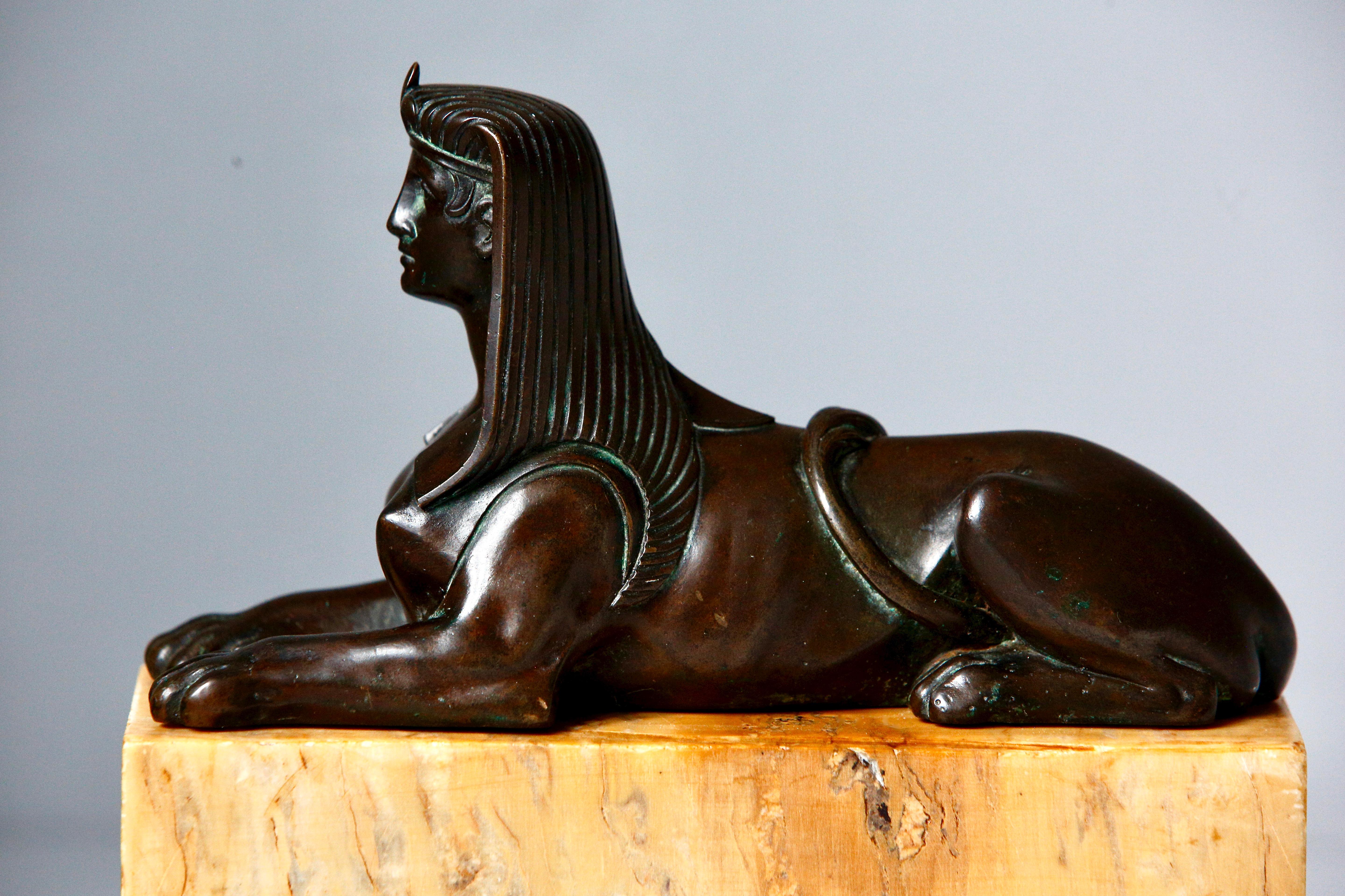 A French Empire finely cast bronze model of recumbent sphinx on a sienna marble base,  circa 1840.

The bronze with the warm golden patina of age is in good condition with minor chips/marks to the edge of the marble. 

The sphinx consists of the