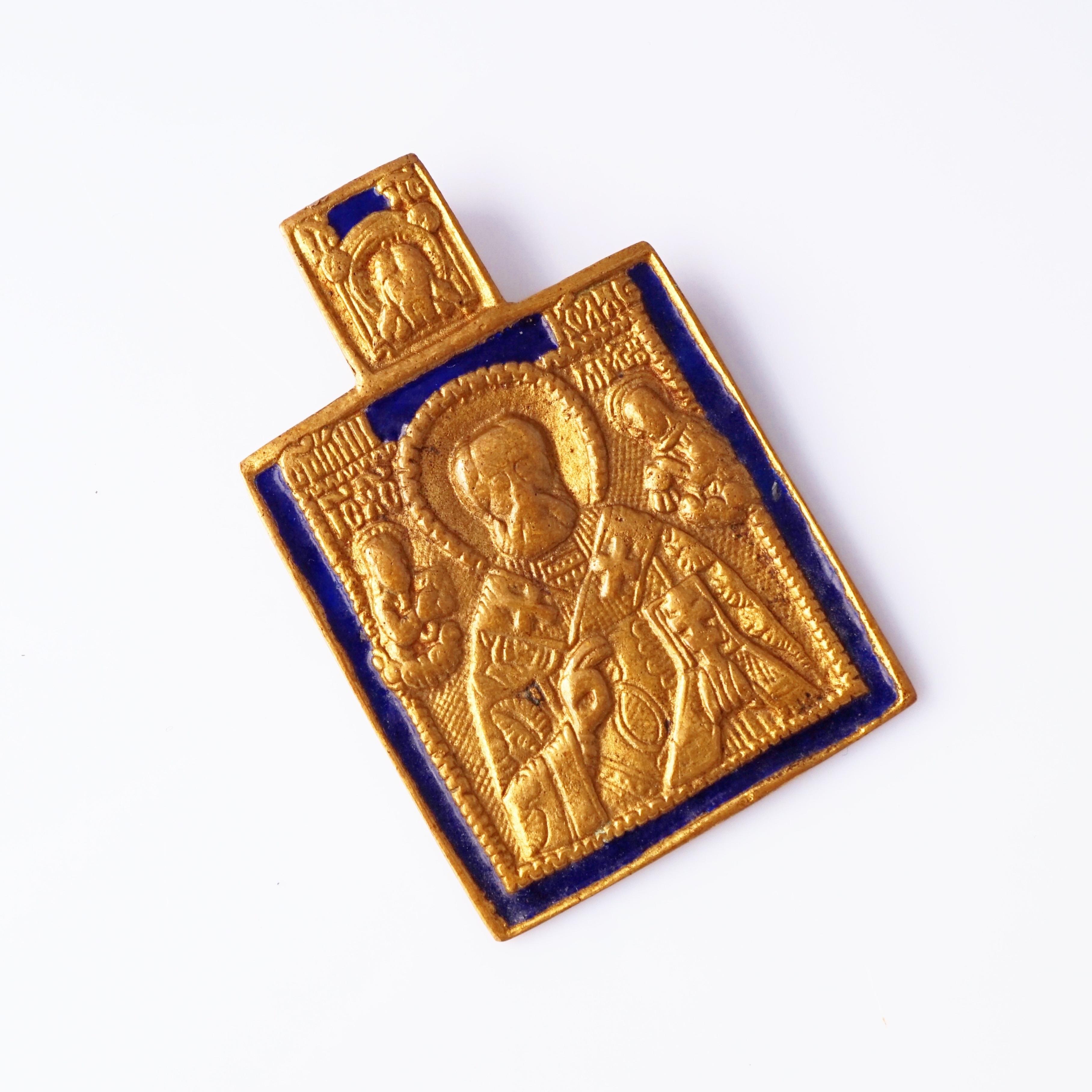 A striking example of French mid-century artistry, this 1960s Line Vautrin pendant depicts St. Nicholas rendered in finely detailed bronze relief, bordered with rich cobalt blue enamel. Vautrin’s signature blend of mysticism and modernism shines