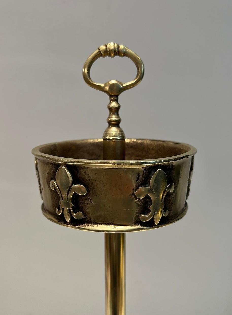 This standing ashtray is made of brass and bronze with lily flower decor. This is a French work. Circa 1940