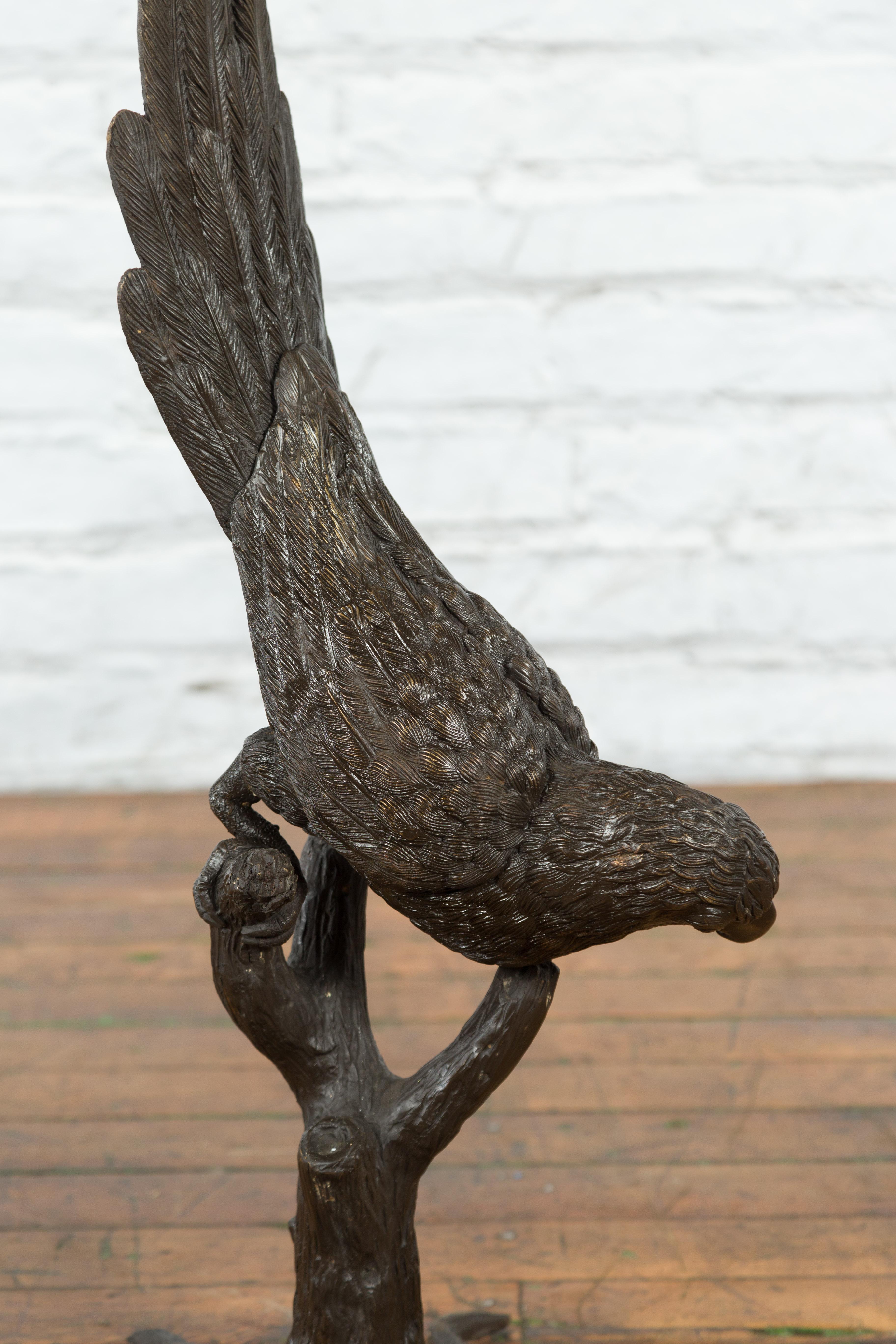 Contemporary Bronze Statue of a Parrot Perched on a Branch and Leaning Down, with Dark Patina For Sale
