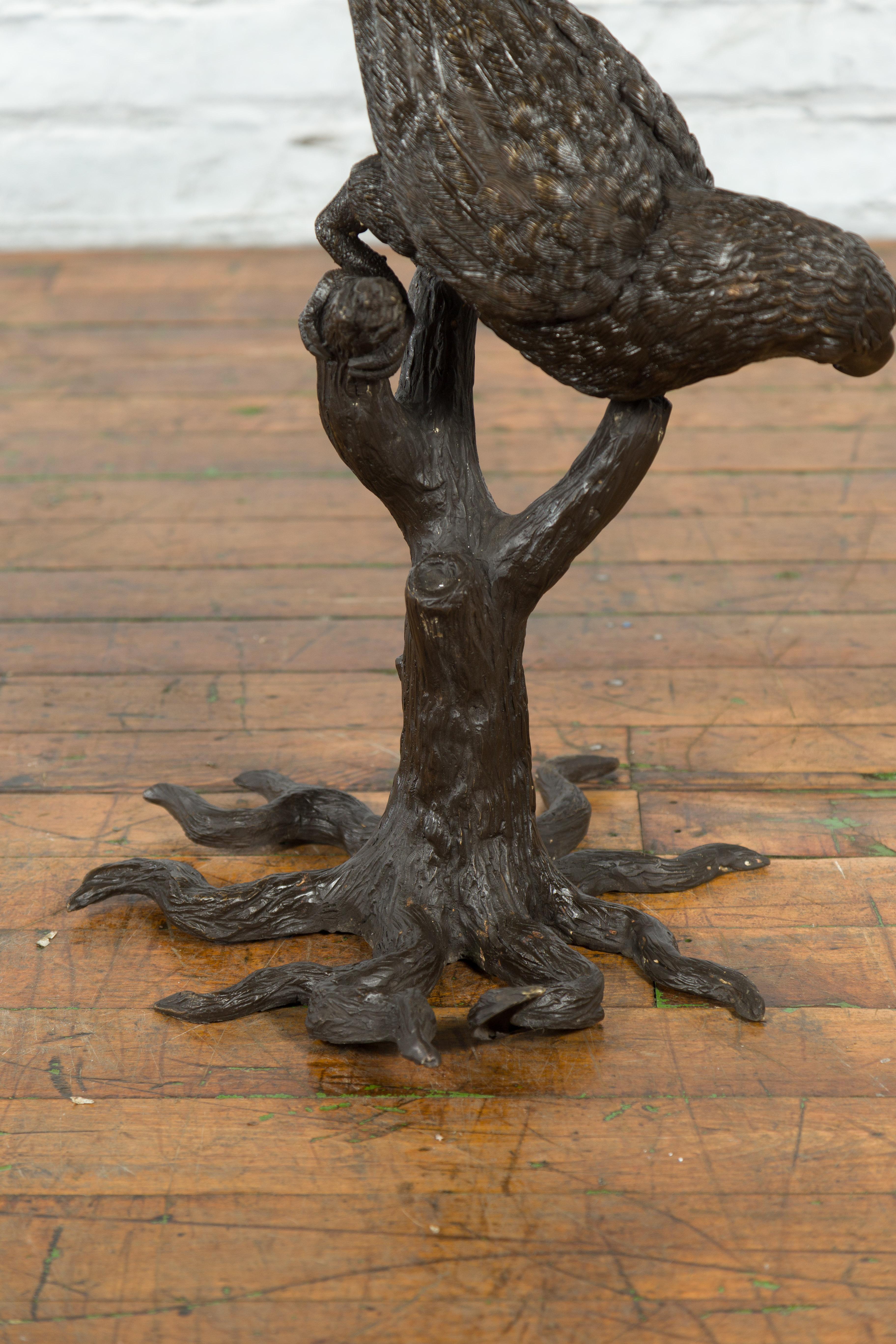 Bronze Statue en bronze d'un perroquet perché sur une branche et allongé, avec patine foncée en vente