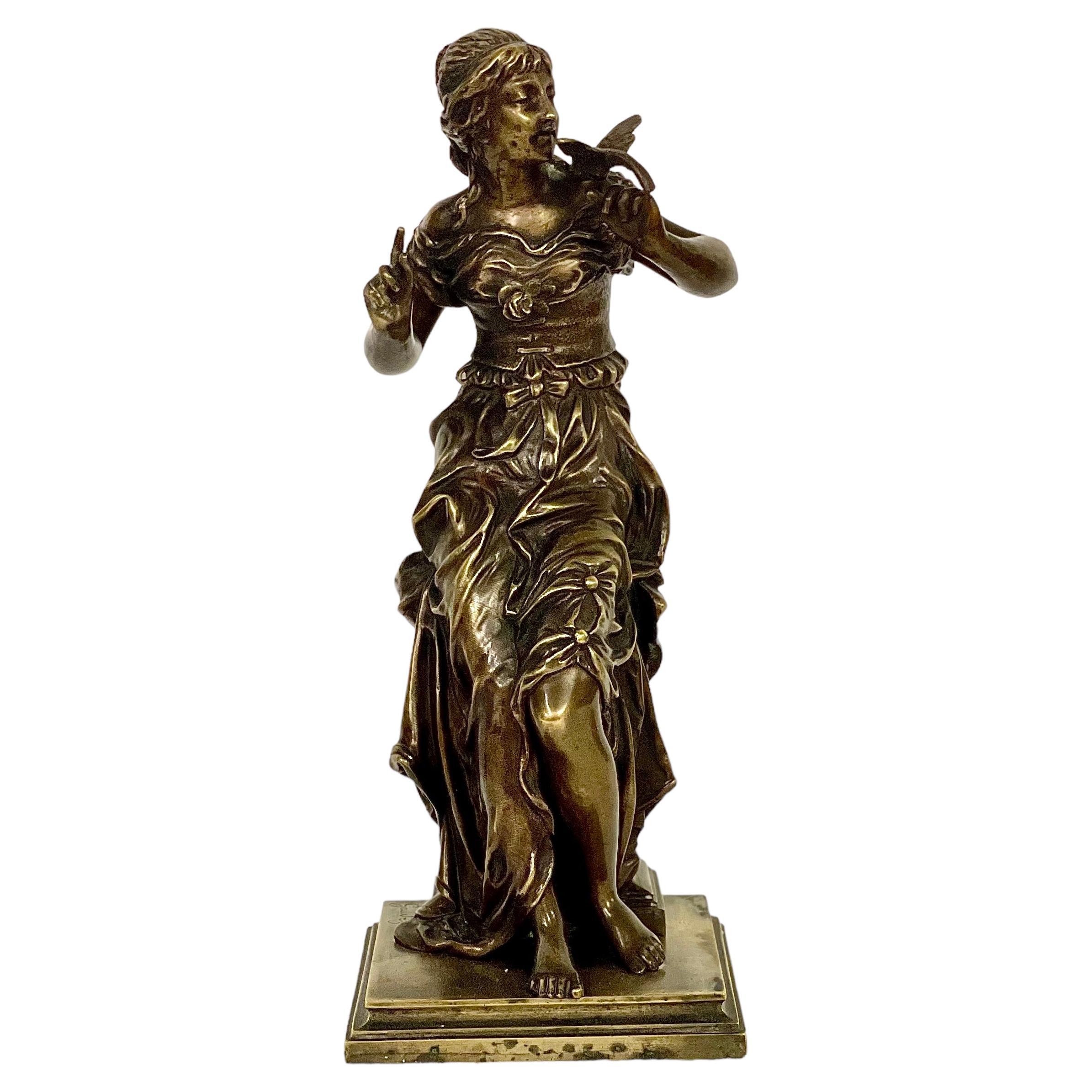 Estatua francesa de bronce del siglo XIX de una mujer joven con un pájaro, por A.E. Gaudez