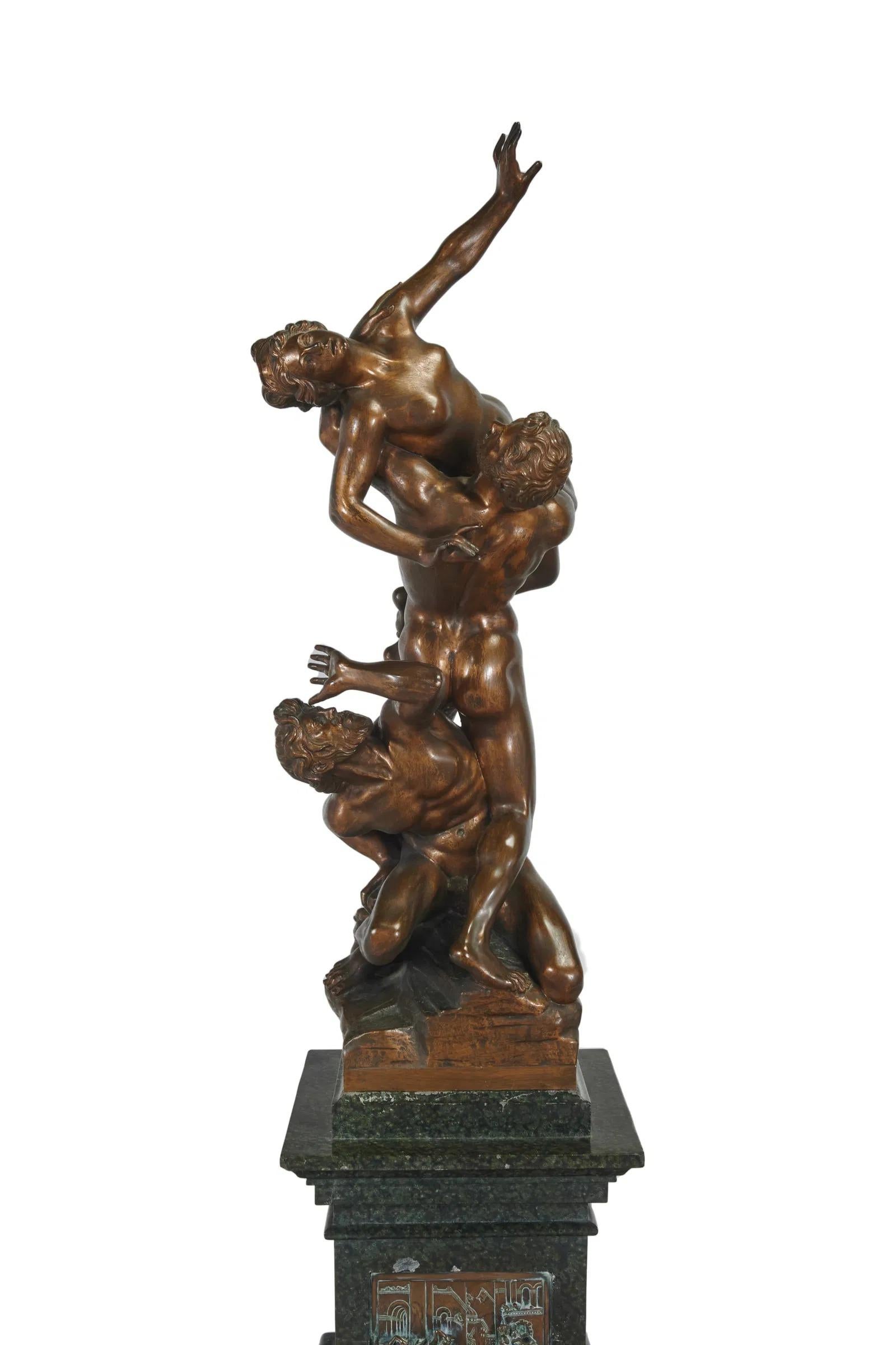 Fino vaciado del Rapto de la mujer sabina según Giambologna (1529-1608), montado sobre pedestal de mármol con relieve de bronce del mismo tema, colocado sobre pedestal de madera.  El bronce mide 41 1/2 por 13 por 13 pulgadas.  La base de mármol