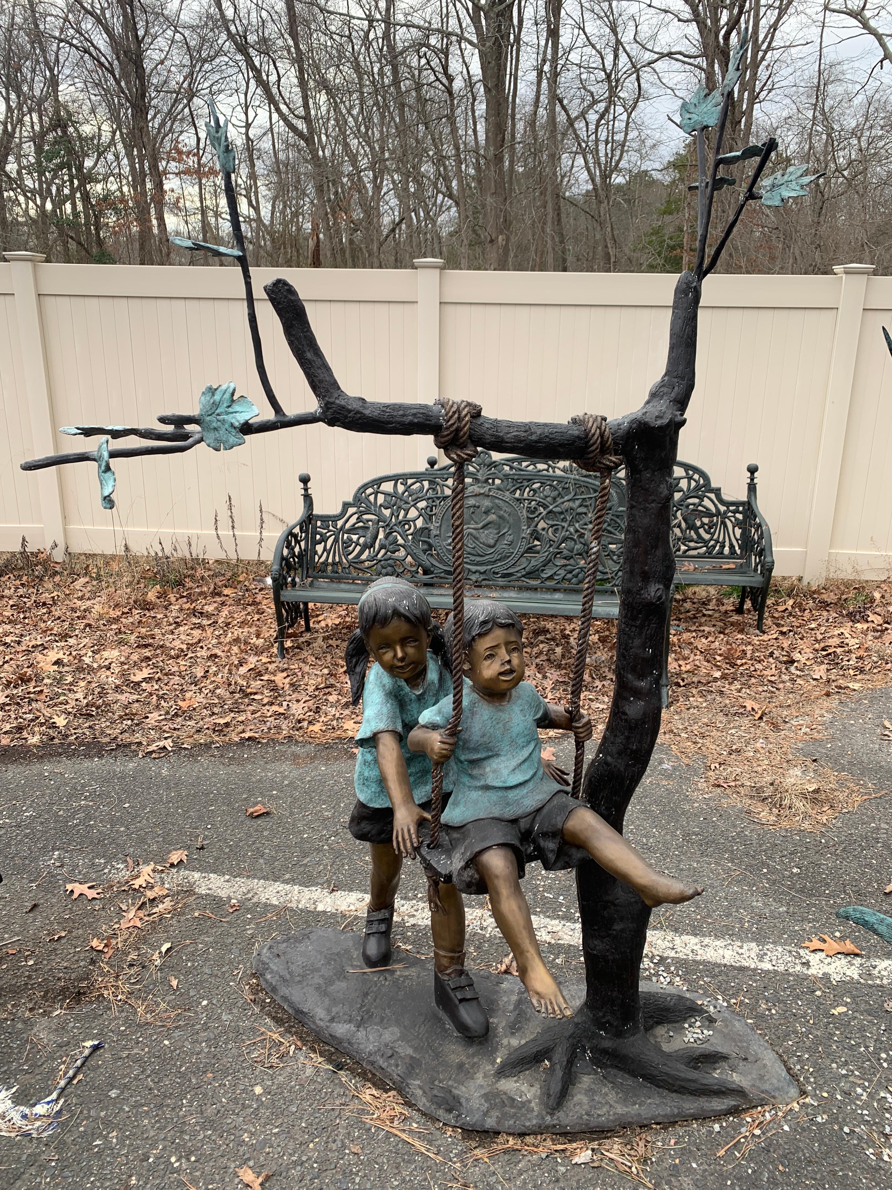 Beautiful bronze garden statue of boy and girl on tree swing. Please confirm location with seller (NY or NJ)