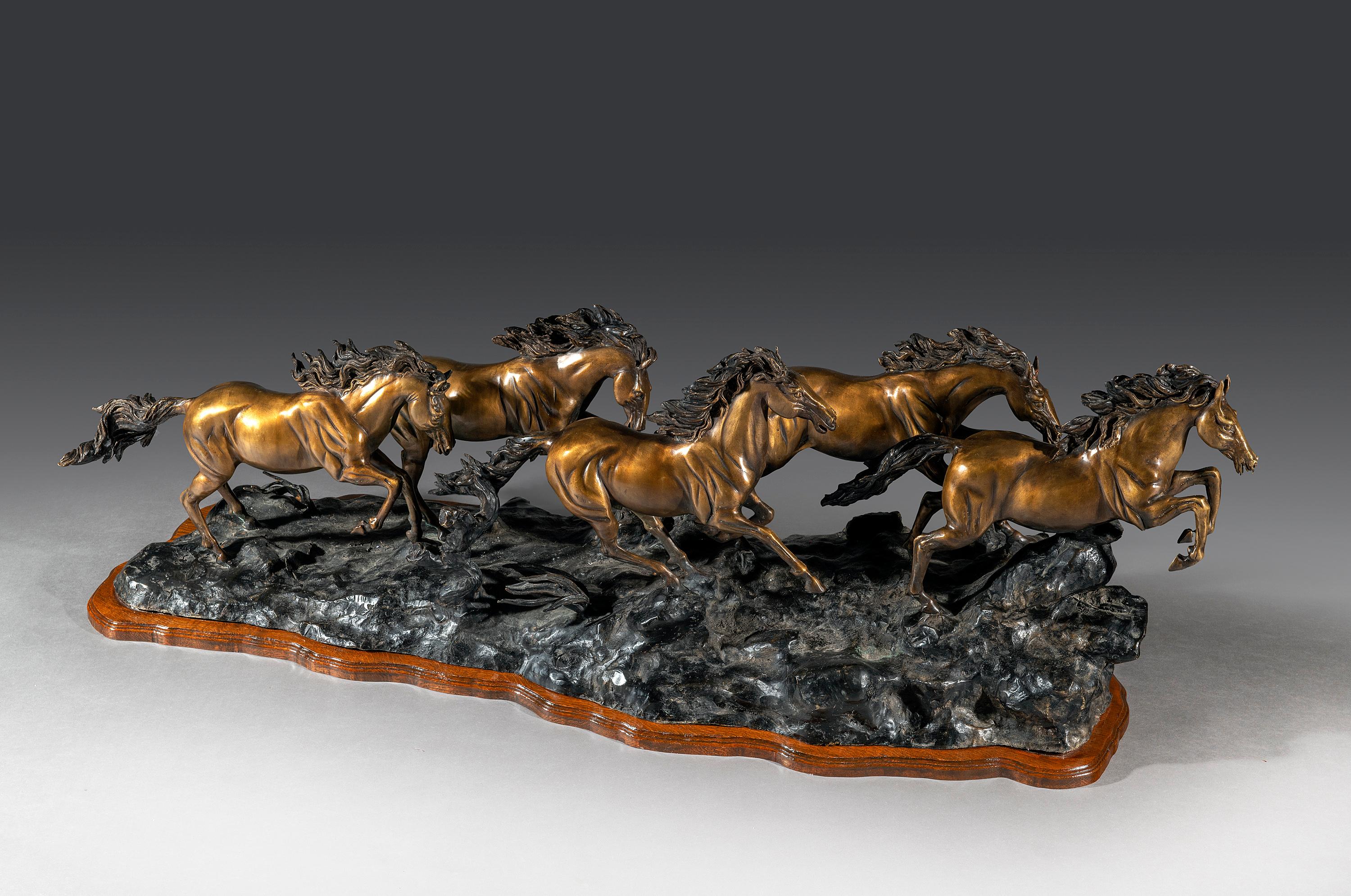 Grande e imponente statua in bronzo dell'inizio del XX secolo raffigurante cinque cavalli mustang al galoppo.