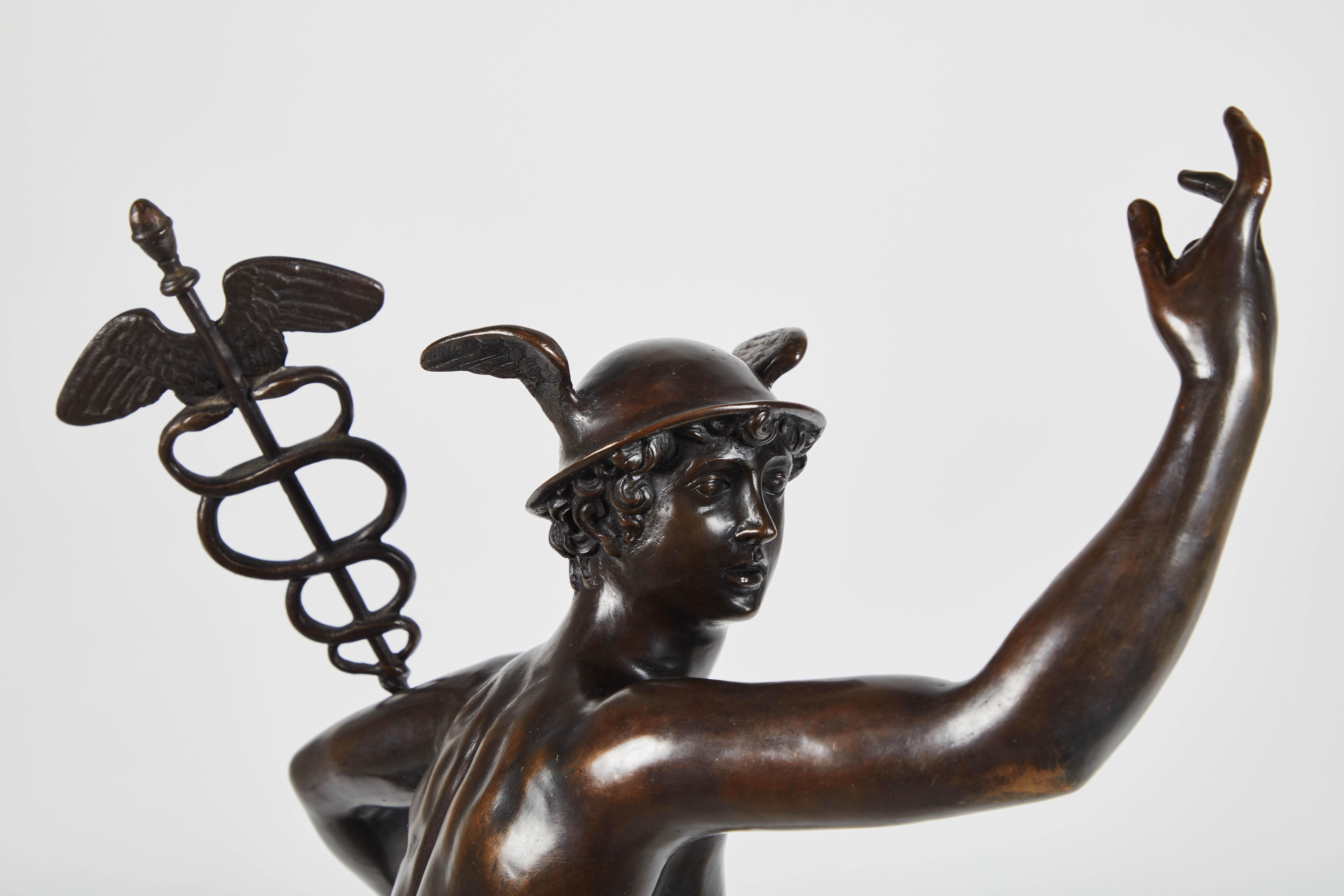 Large patinated bronze sculpture representing Mercury, the messenger of the gods. He is wearing his winged, round petasos hat and carrying a caduceus in his left hand. The wings on his ankles enable him to move quickly and are one of his distinctive