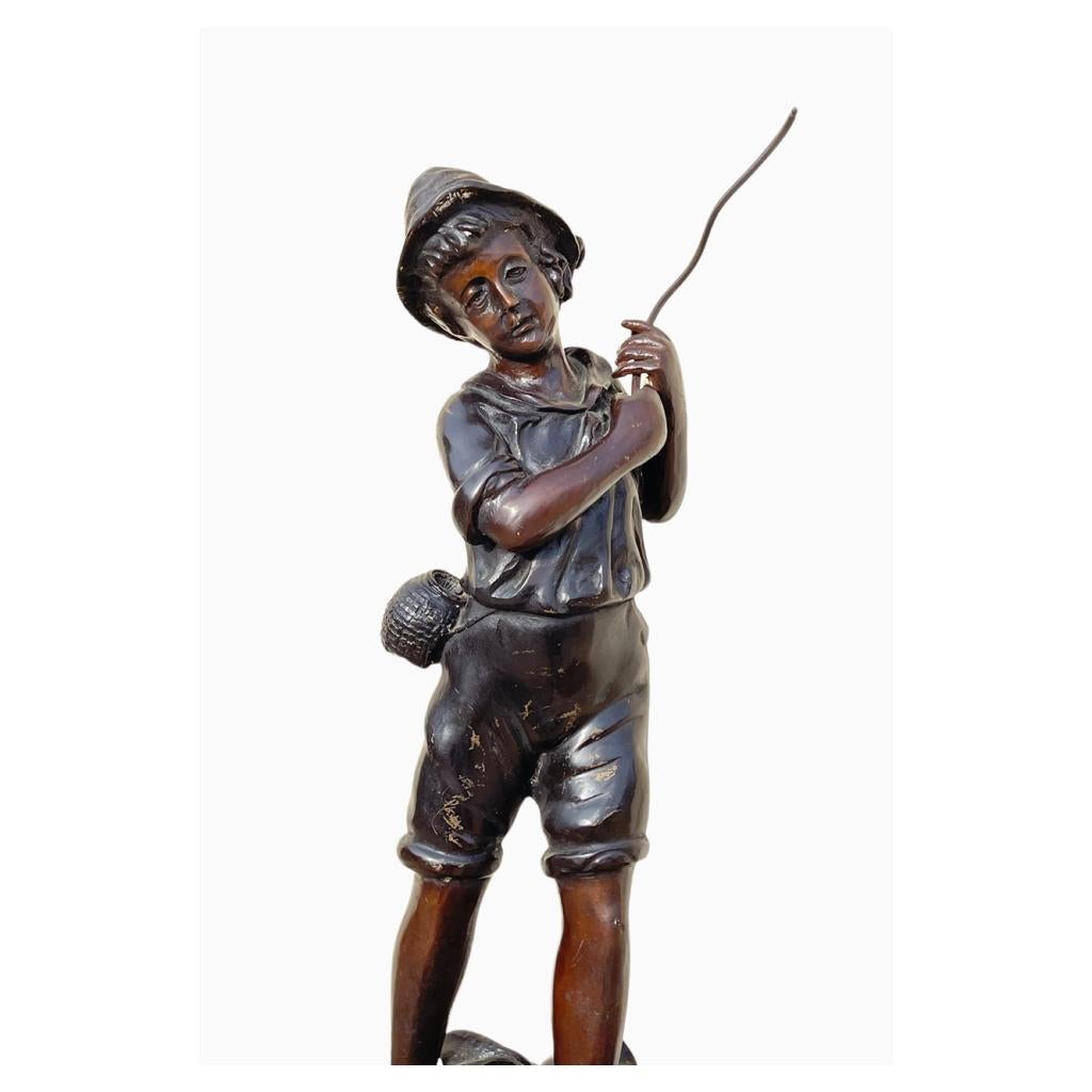 Bronze with brown patina representing a young barefoot boy in the water engaged in fishing. Good condition, circa 1950.