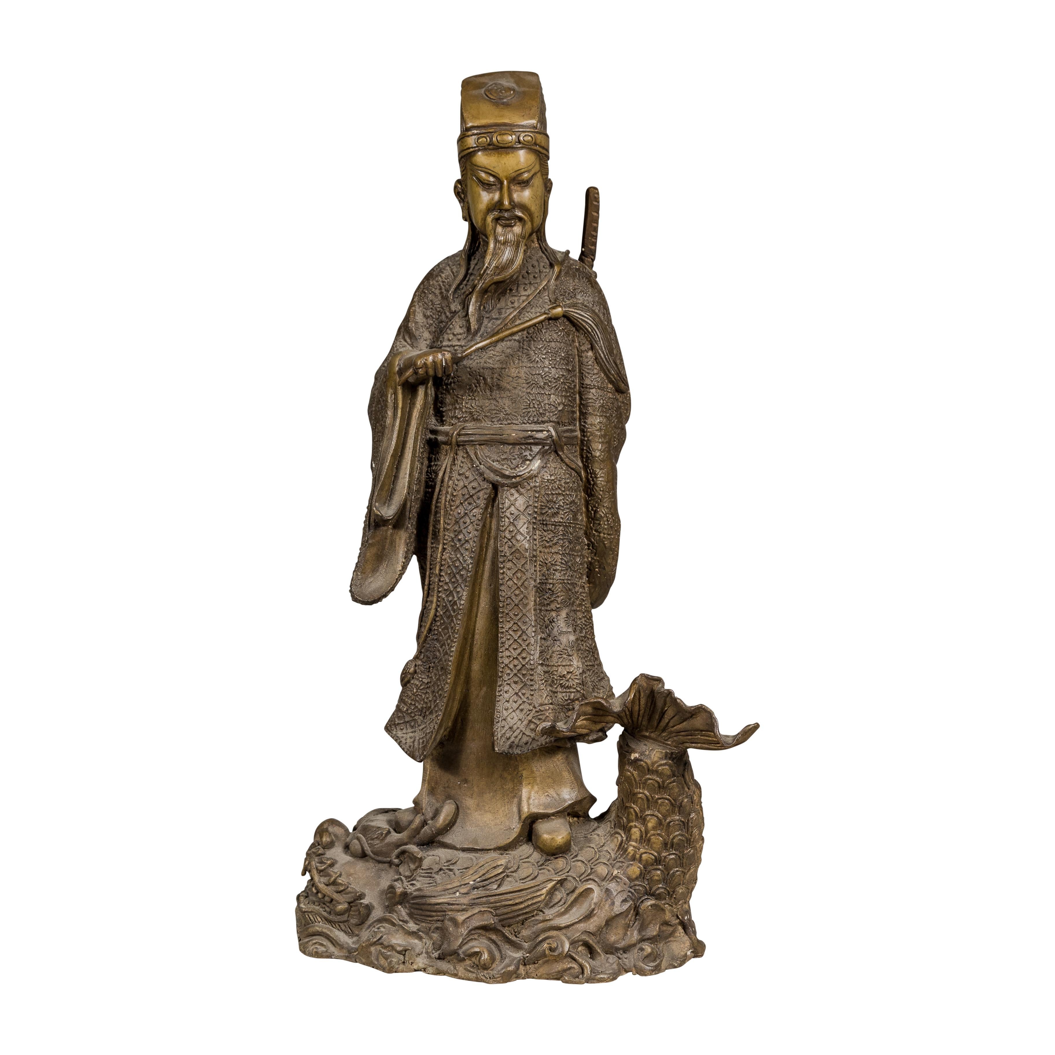 A bronze vintage statuette depicting a Chinese ancestral figure standing on a giant fish. Discover a magnificent fusion of artistry and heritage with this vintage bronze statuette, intricately depicting a revered Chinese ancestral figure, poised