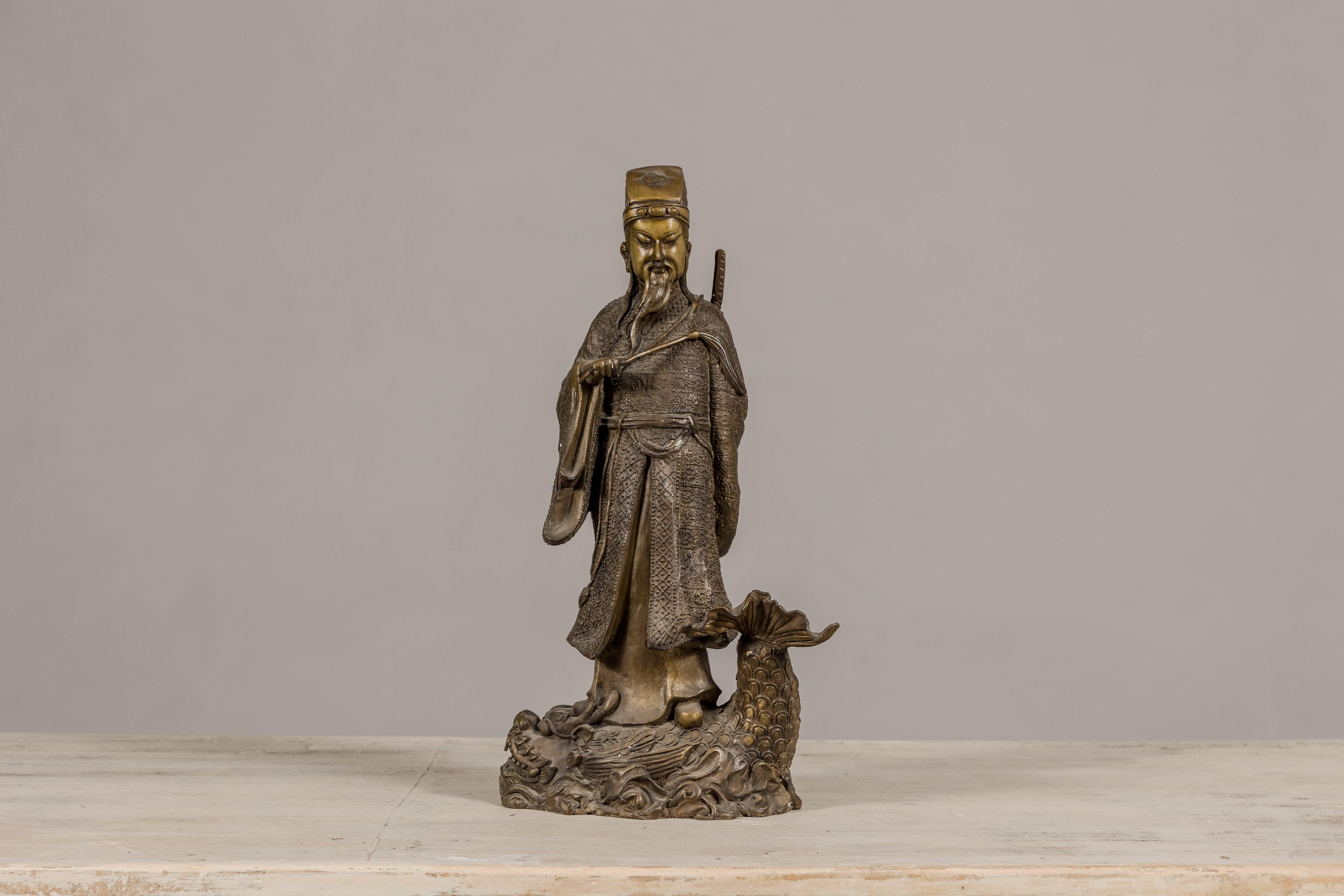 Chinois Statuette en bronze d'une figure ancétrique chinoise debout sur un poisson géant en vente