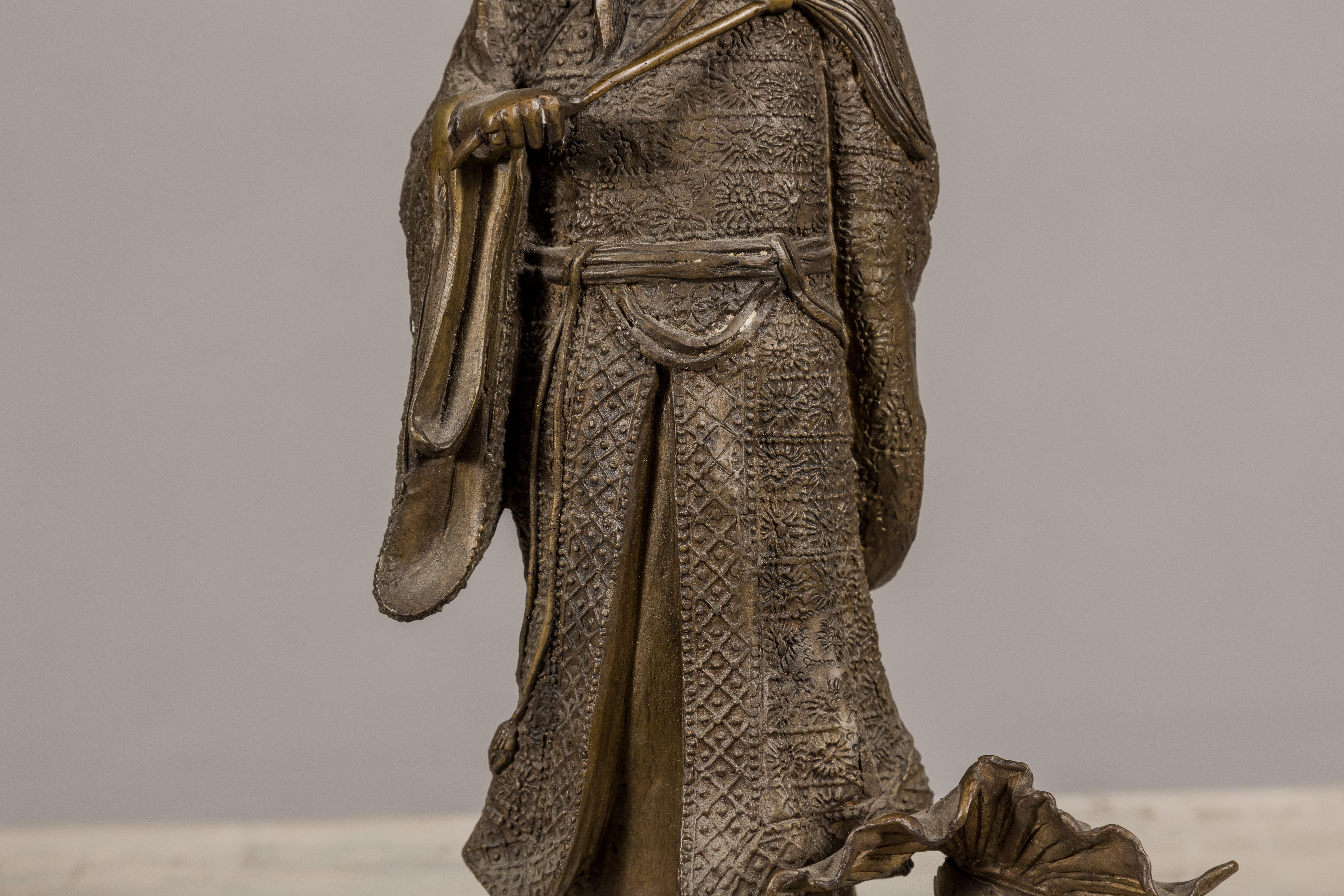 Bronze Statuette en bronze d'une figure ancétrique chinoise debout sur un poisson géant en vente