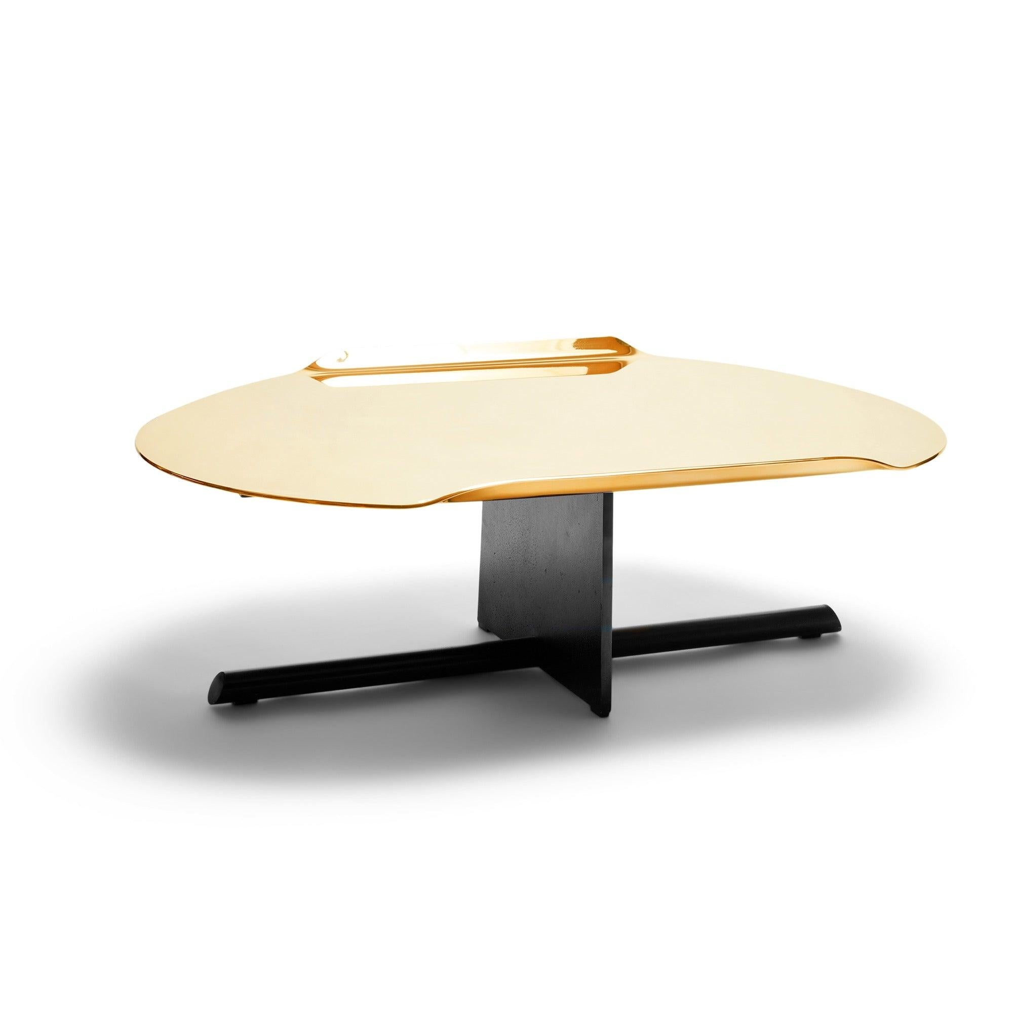 Un tablero de mesa de bronce personalizado con bordes acampanados sobre una base de acero única compuesta por un plano estilizado y una varilla biselada.