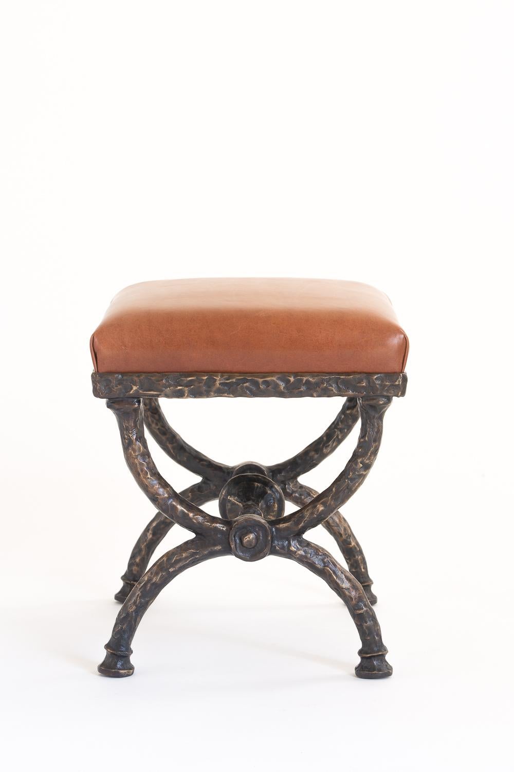 Dieser handgeformte Hocker aus Bronze ist handgeschmiedet und mit einem Sitz aus braunem oder schwarzem Leder ausgestattet. Jedes Stück ist nummeriert und gestempelt. Sondergrößen und -ausführungen sind erhältlich.