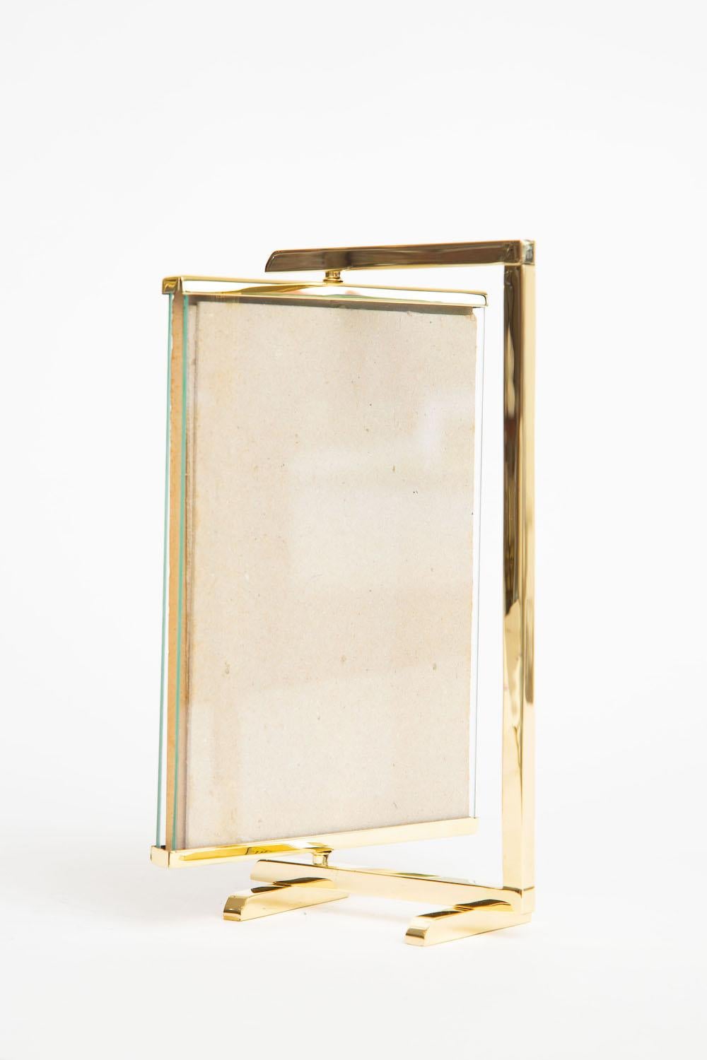 This vintage bronze fully polished picture frame is Mid-Century Modern and swivels and pivots to two sides for 2 photographs. It was made by Silvestri Company and still retains that piece of paper in the frame. It is elegant, simple and modern. It