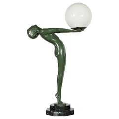 Lampada da tavolo in bronzo raffigurante una fanciulla nuda che tiene in mano una sfera di vetro