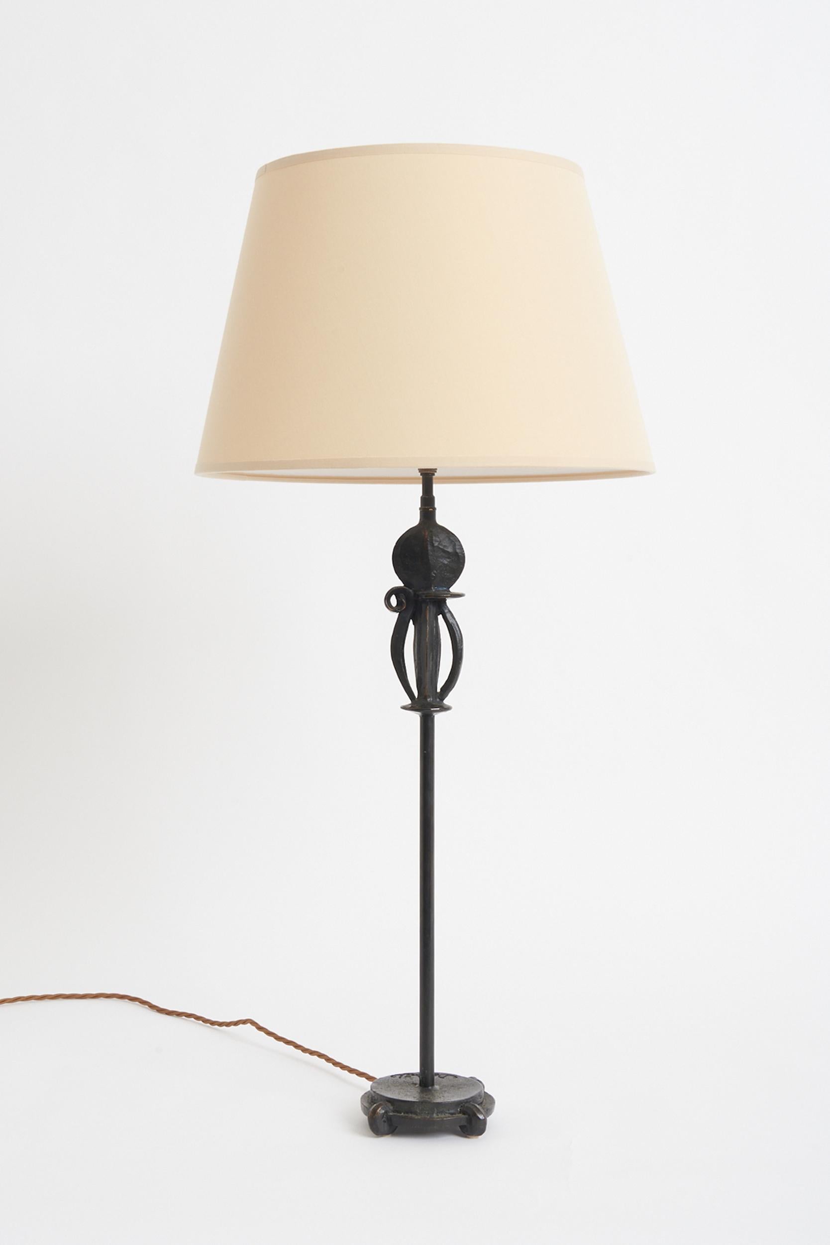 A bronze table lamp. Signed, unidentified.
France, 20th century. 
Measures: with the shade: 75 cm high by 36 cm diameter 
lamp base only: 57 cm high by 14 cm diameter.