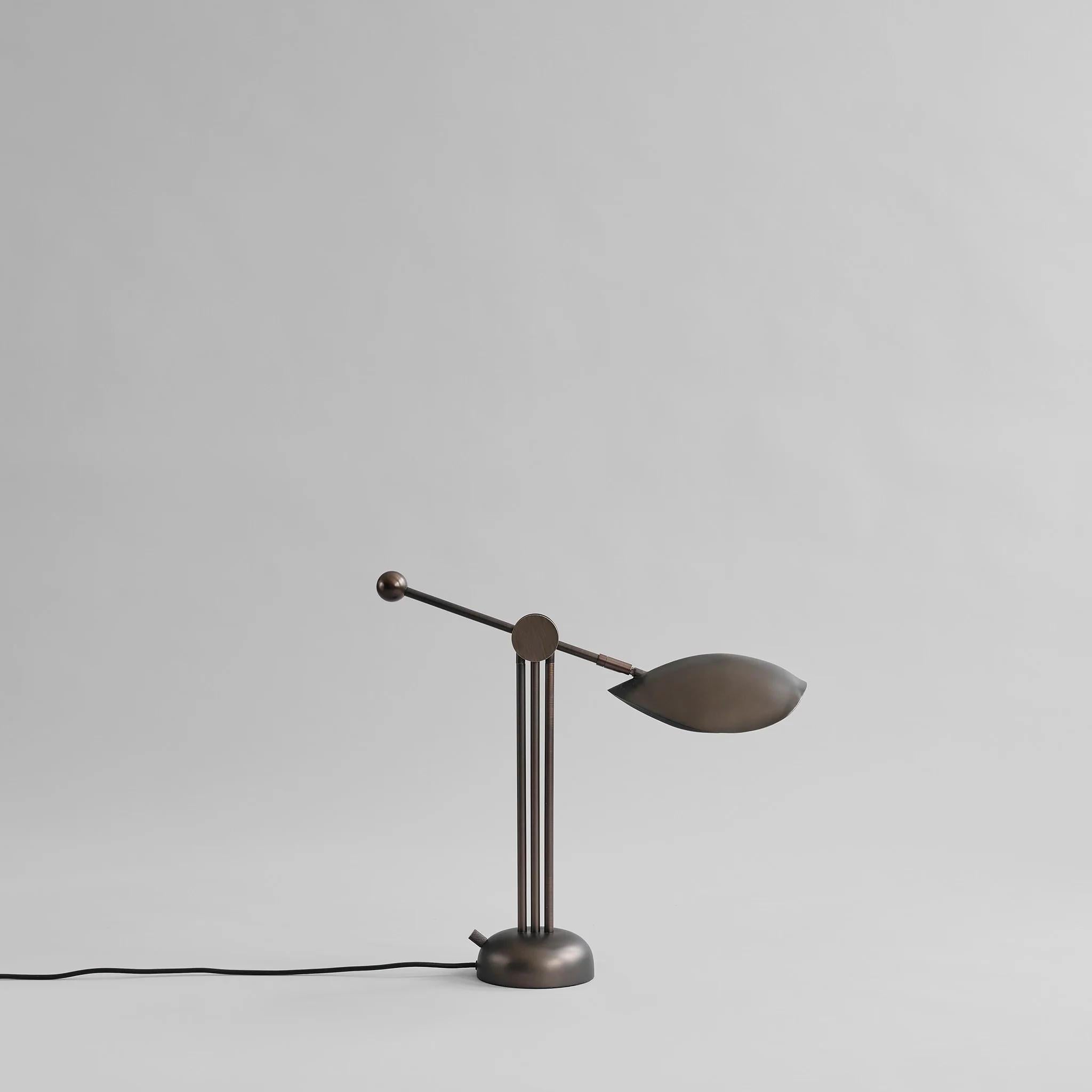 Bronze table lamp in the style of the 1960s, a contemporary work.

This table and floor lamp features three legs, adding a certain rhythm and simplicity. The shade is mounted on an adjustable lamp arm. 

Colour / material: bronze finish, bronze