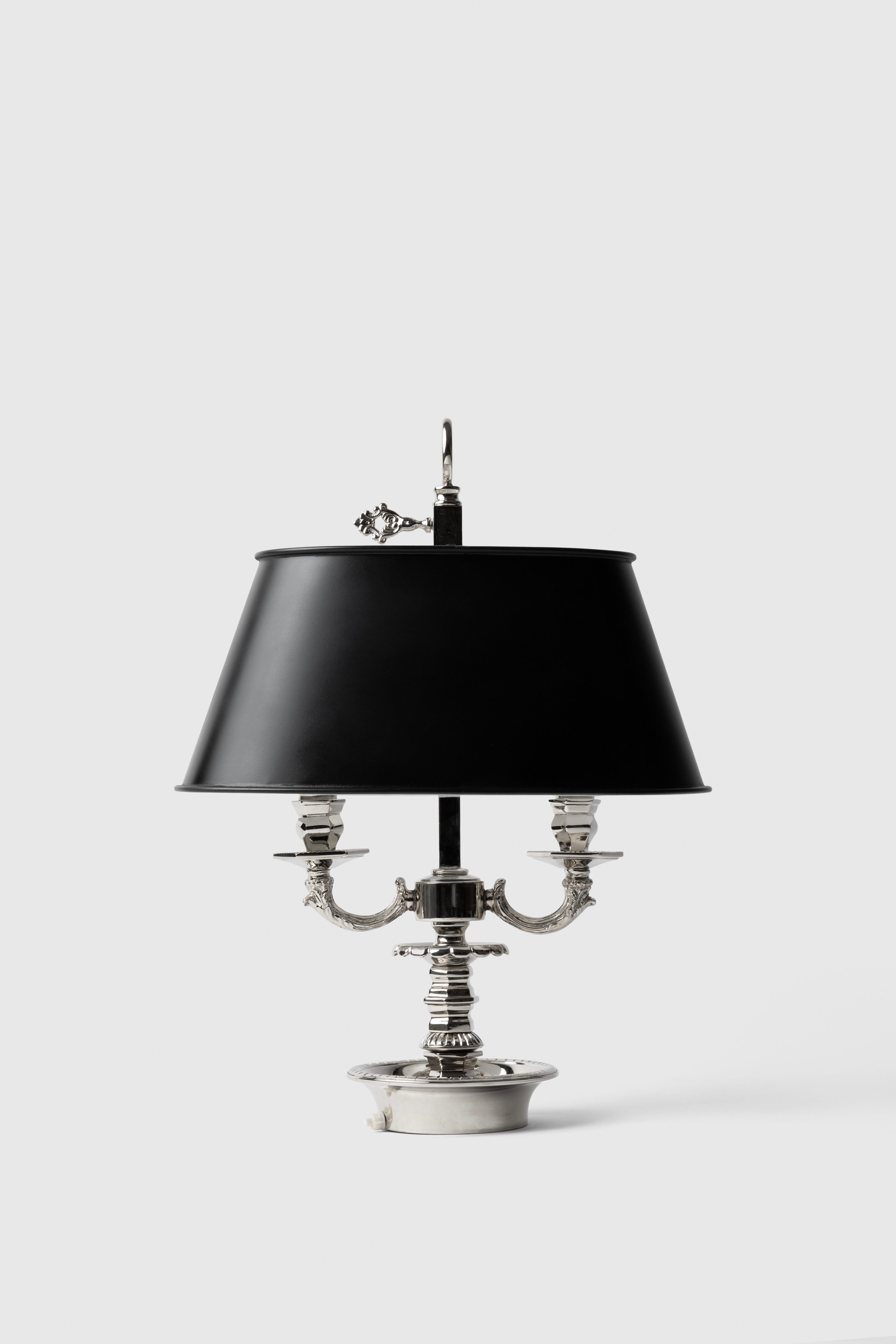 This bronze table lamp is carved in brass with a black leather lampshade, two arms and carved details. 

It is in the style of a 19th century Louis XVI Bouillotte lamp and the designs in the arms and top details are inspired by the study and