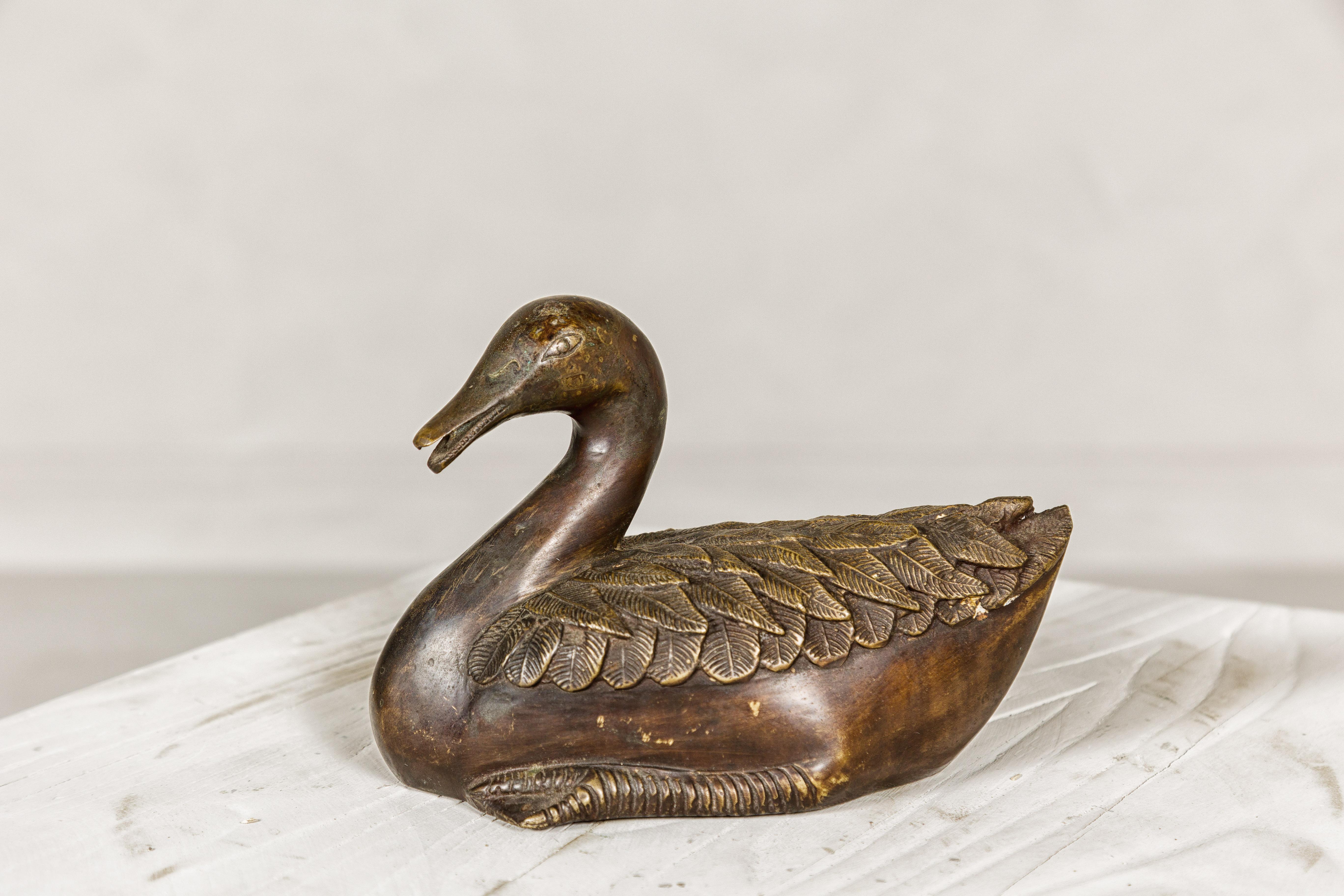This vintage bronze duck tabletop statuette is a charming and intricately detailed piece, showcasing the exquisite craftsmanship of the lost wax process. The fine details on the feathers are a testament to the meticulous work involved in its
