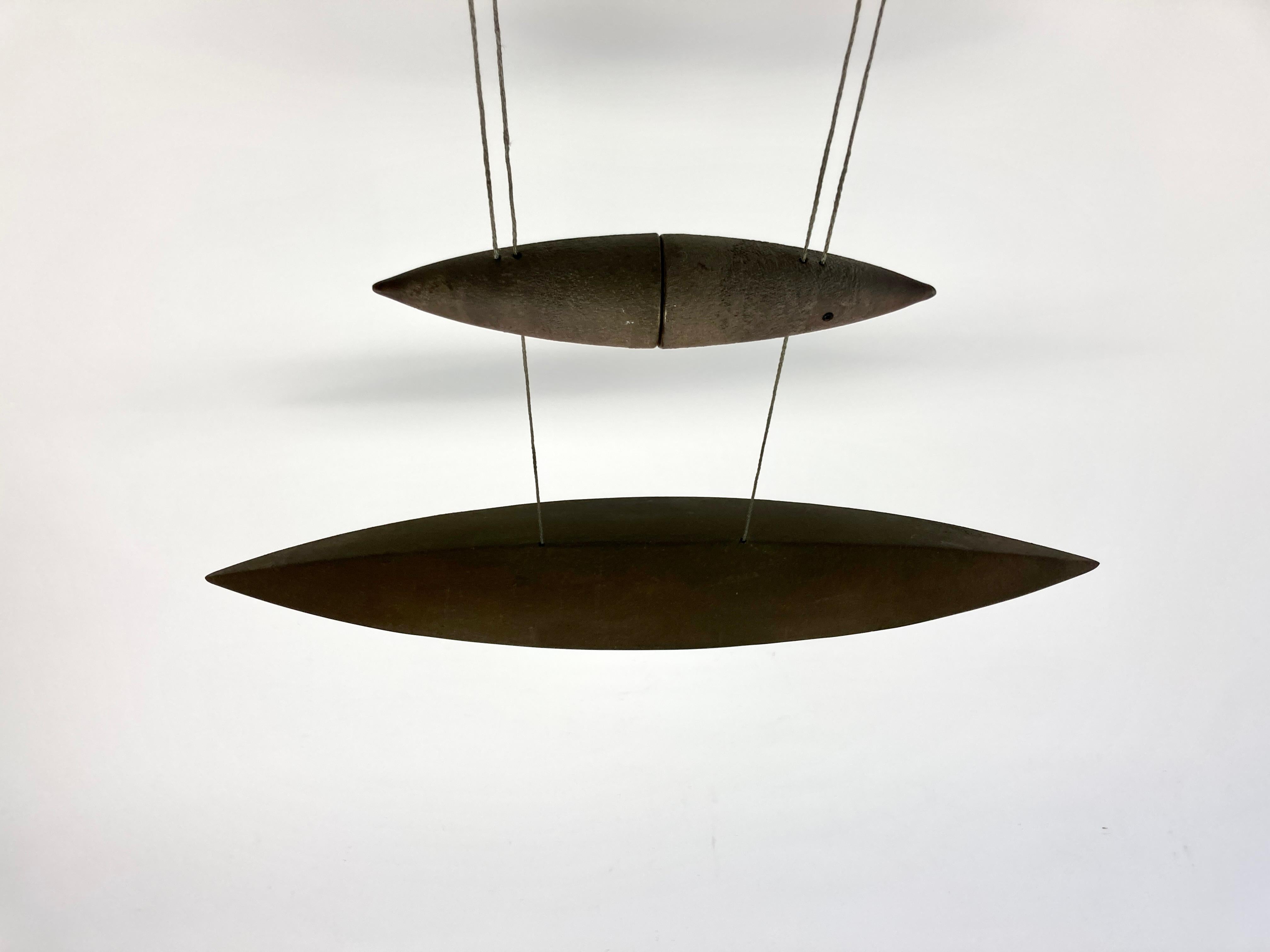 Elegant bronze Tai Lang pendant light designed by Tobias Grau, Germany.

High grade raw bronze top contrasted with polished bronze around the edges of the light source. Soft light is dispersed downwards through opal glass.

The shade is balanced by