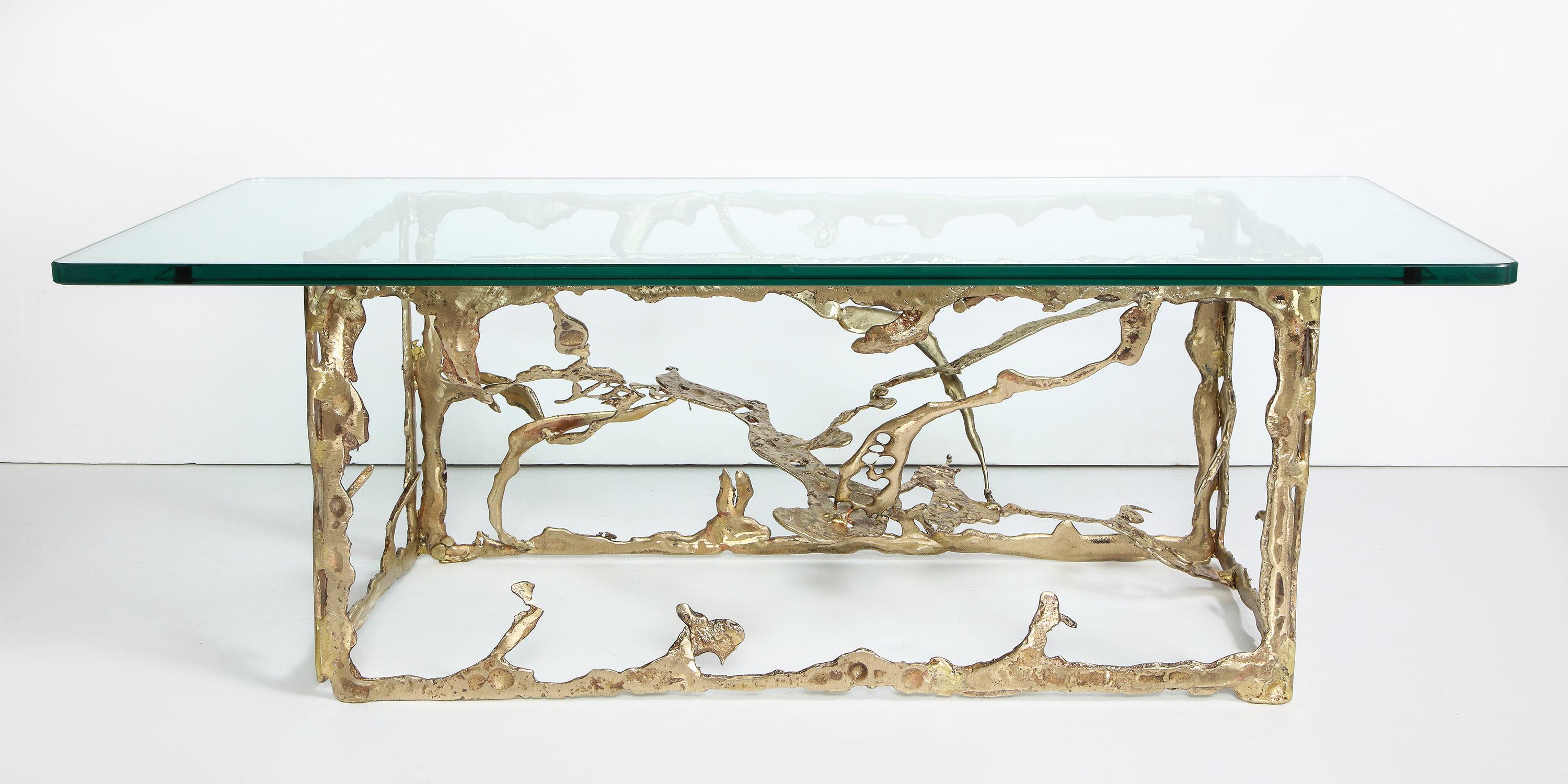 The rectangular freeform cast bronze base supporting a glass top.

Signed Silas Seandel.
