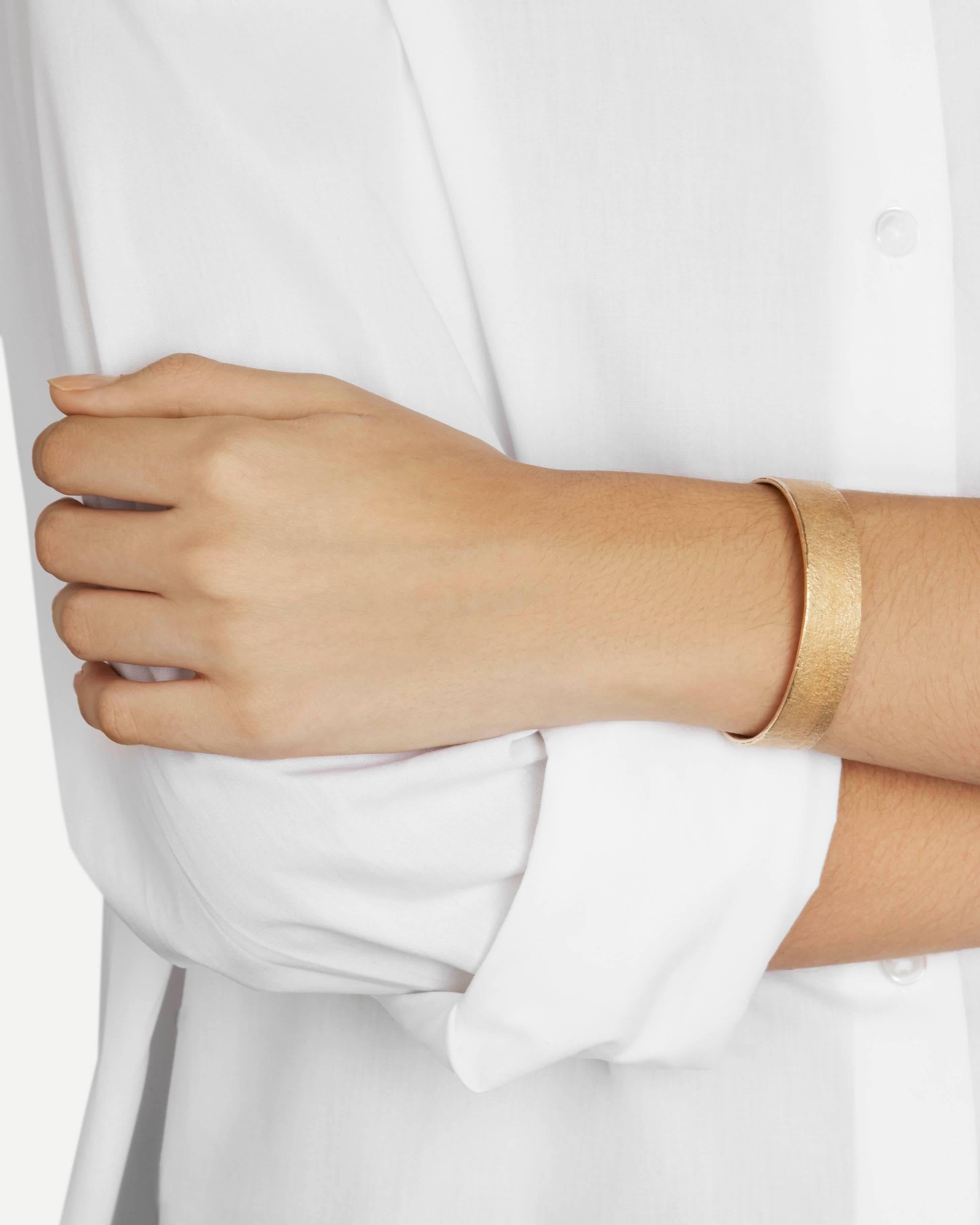 This clean-lined cuff bracelet features a rustic texture in warm, glowing solid bronze.  

Every piece in this collection is individually hand-crafted in paper and cast directly into precious metal in a unique and innovative process.  Every piece