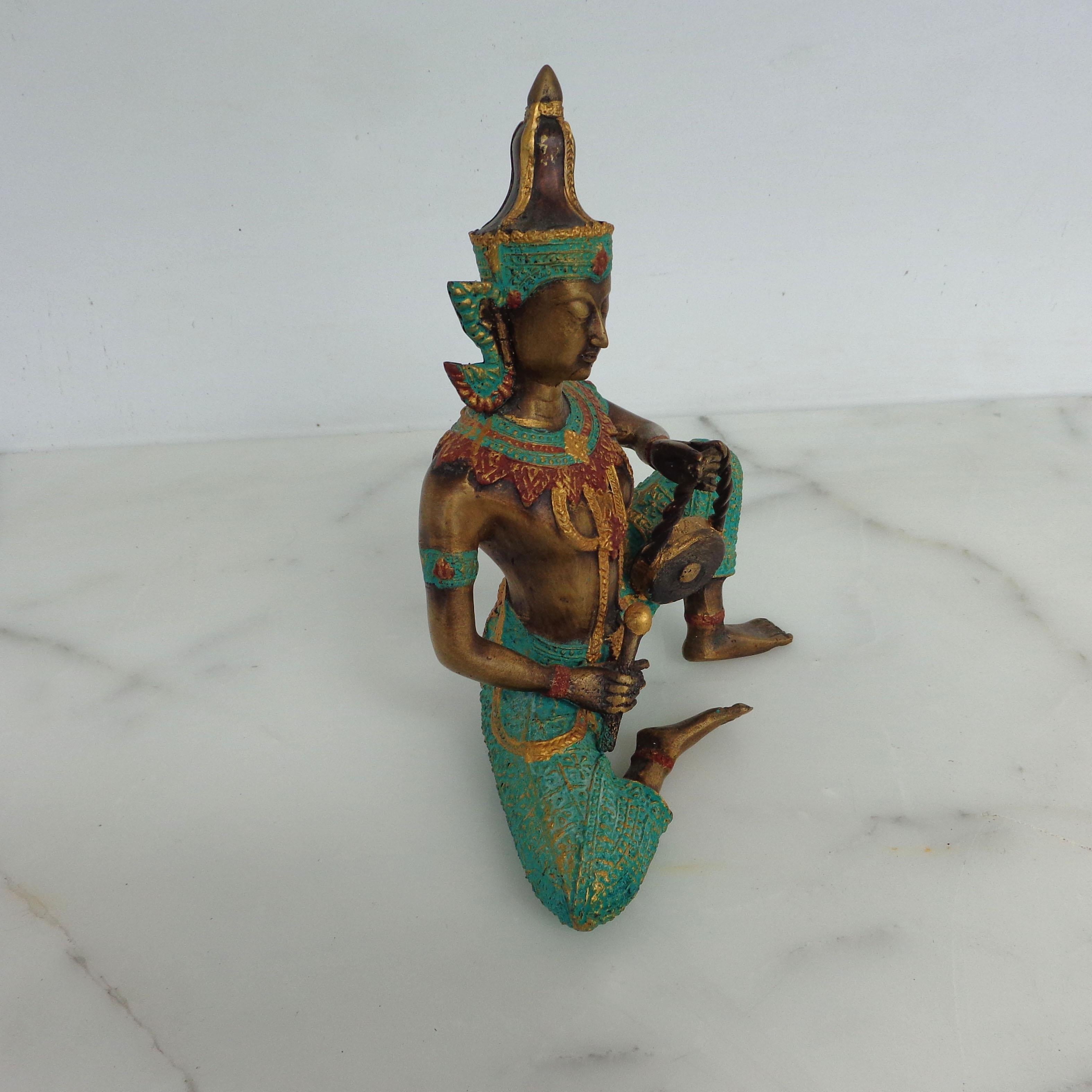 Statua in bronzo di un musicista in costume cerimoniale che suona uno strumento tradizionale a tamburo.
Ricco di colori e dettagli.
 

 