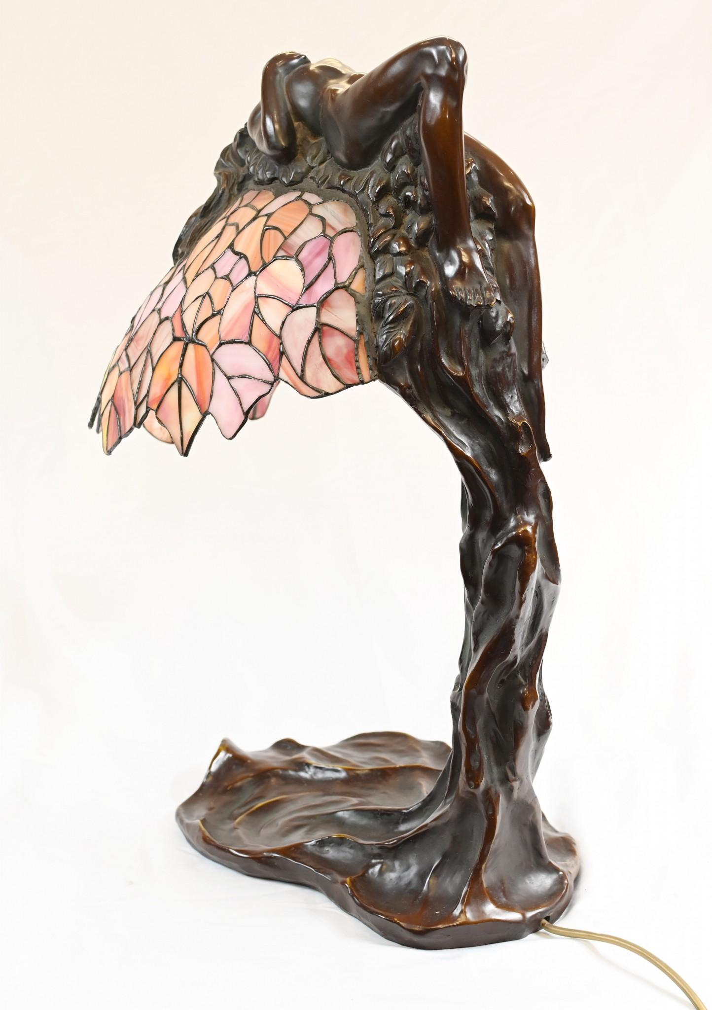 An unusual art nouveau style Tiffany lamp with a bronze female arched over the leaded glass shade.
Circa 1950
Classic Tiffany shade with lovely shades of pink
Purchased from a dealer on Rue de Rossiers at the Paris antiques markets
Some of our