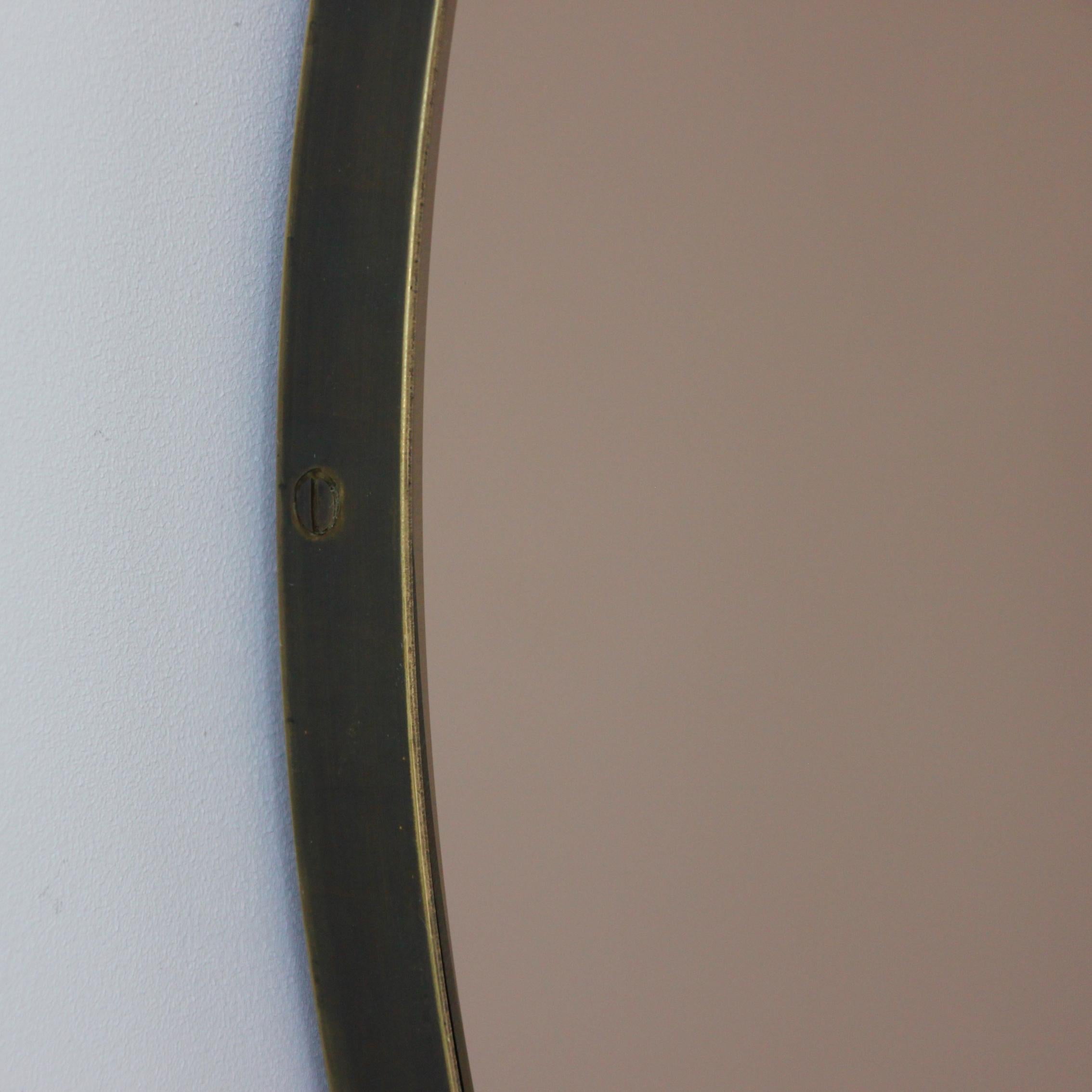 Contemporary bronze tinted round mirror with an elegant bronze patina brass frame. Designed and handcrafted in London, UK.

Fitted with a brass hook or an aluminium z-bar depending on the size of the mirror. Also available on demand with a split