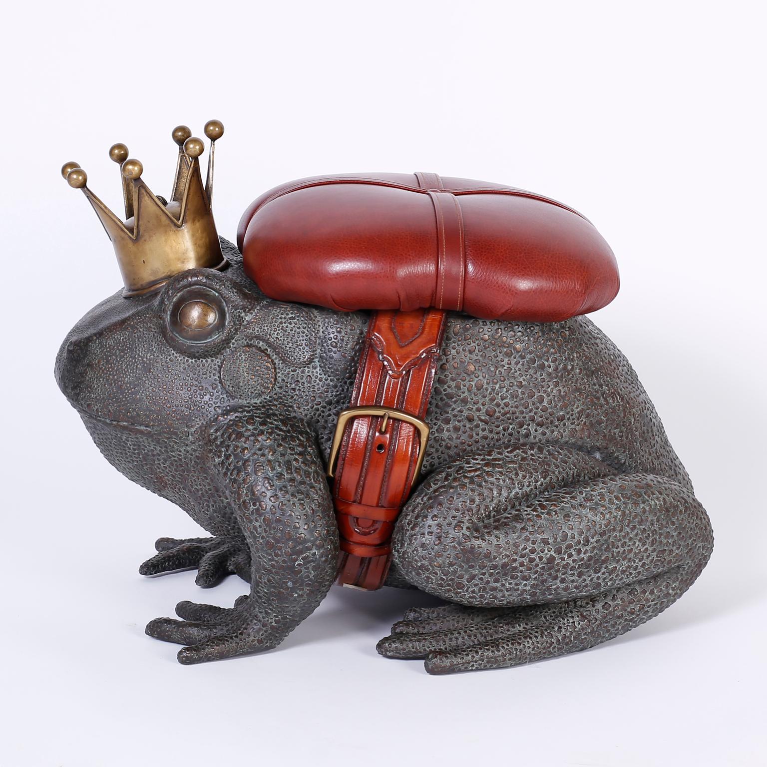 Bronze toad or frog with a classic verdigris patina and featuring a regal crown, oxblood leather button tufted seat and belt, and plenty of decorative appeal. Possibly by Maitland Smith.