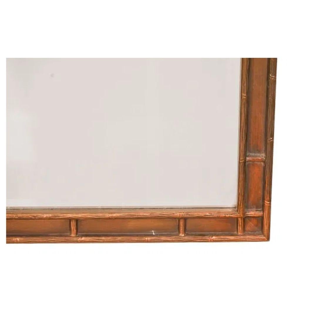 A rectangular faux bamboo framed mirror with bronze tone and geometric bamboo shape