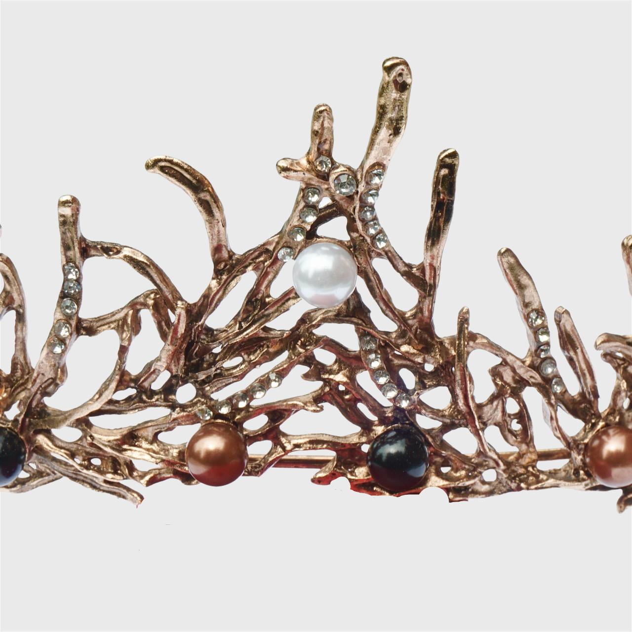 Fabulosa diadema en tono bronce con perlas de imitación blancas y bronce, cuentas negras y brillantes. Tiene un inusual diseño de ramitas.

Mide una anchura máxima en la parte delantera de 5,8 cm. La diadema está en muy buen estado.

Esta