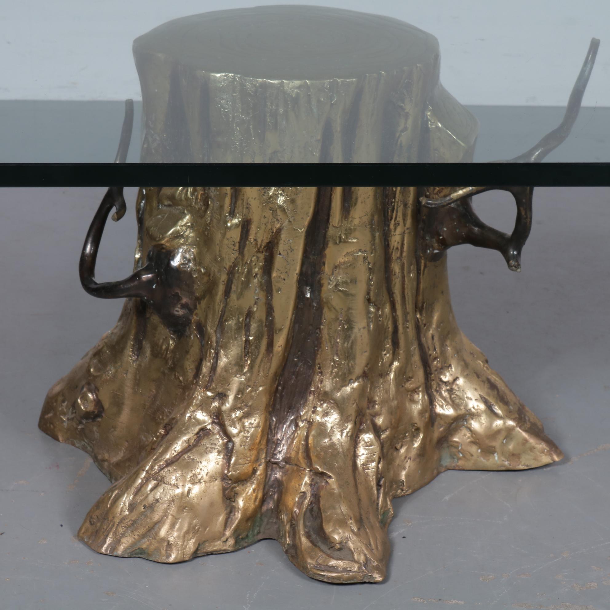 A unique sculptural coffee table, manufactured around 1980.

This rare find is made of high quality bronze in the shape of a tree trunk. Crafted with a fine eye for detail creating the true feel of trunk, roots and nerves, in a golden colour. The
