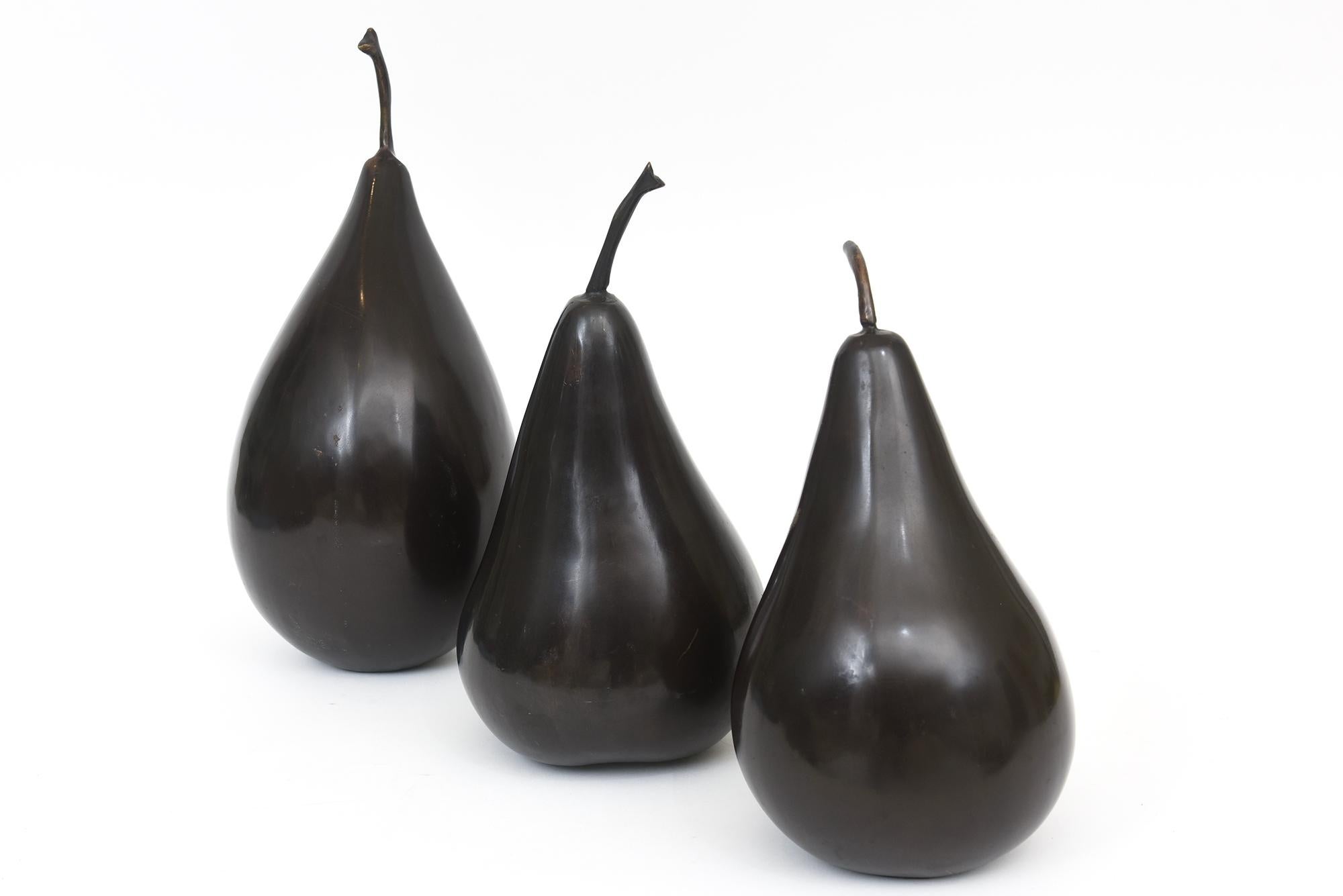 This trio of alternating forms and sizes of 3 abstract style bronze pear sculptures make a great ensemble that can be moved around. From the 80's. The 3 sizes are different and are as follows. Smallest to largest: 13