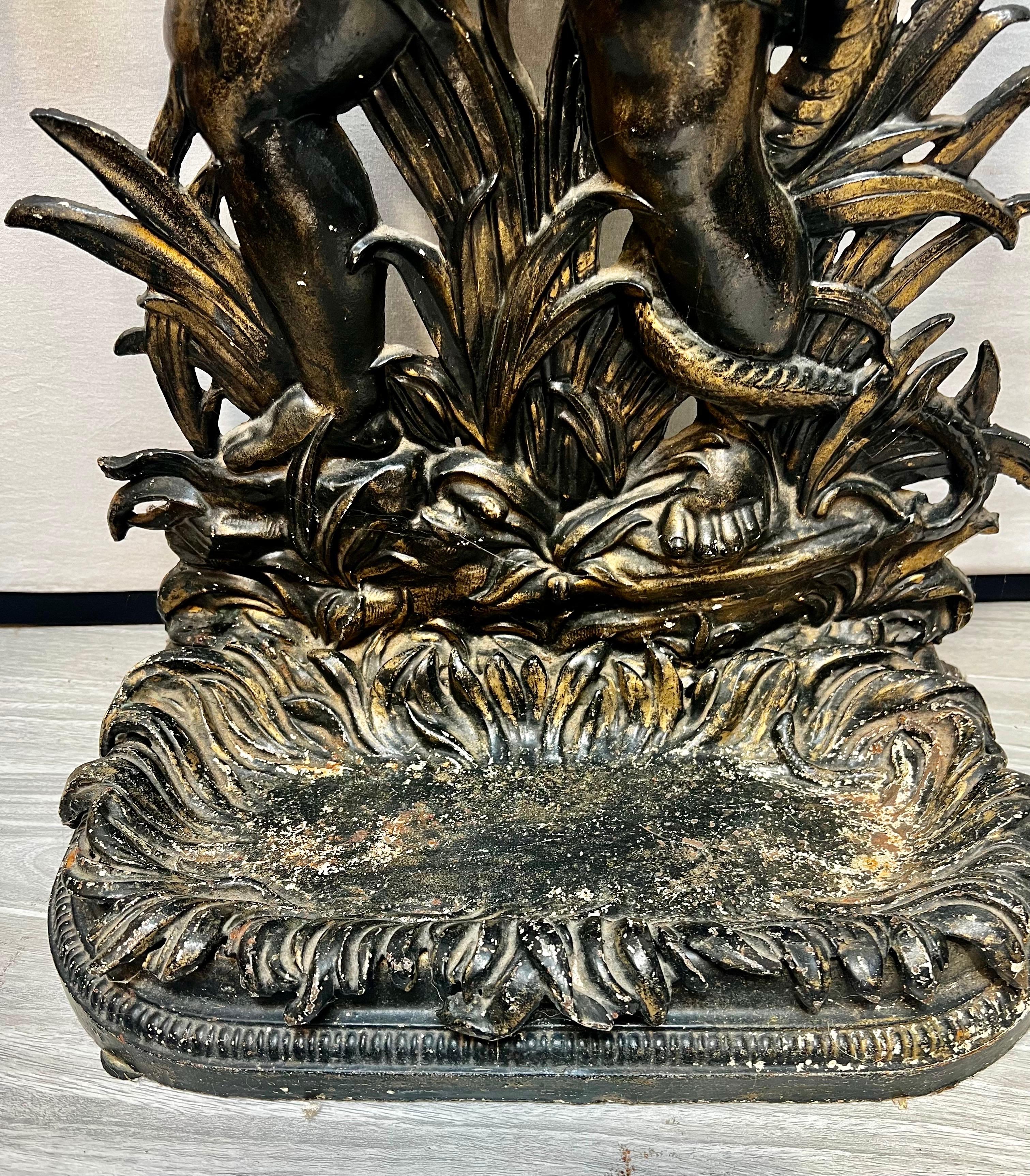Stupendo portaombrelli vintage con la scultura di un bambino putti che tiene in mano un serpente.  Molto insolito.  Credi che il metallo sia bronzo.  Un pezzo di conversazione di sicuro, e un posto per i tuoi ombrelli!